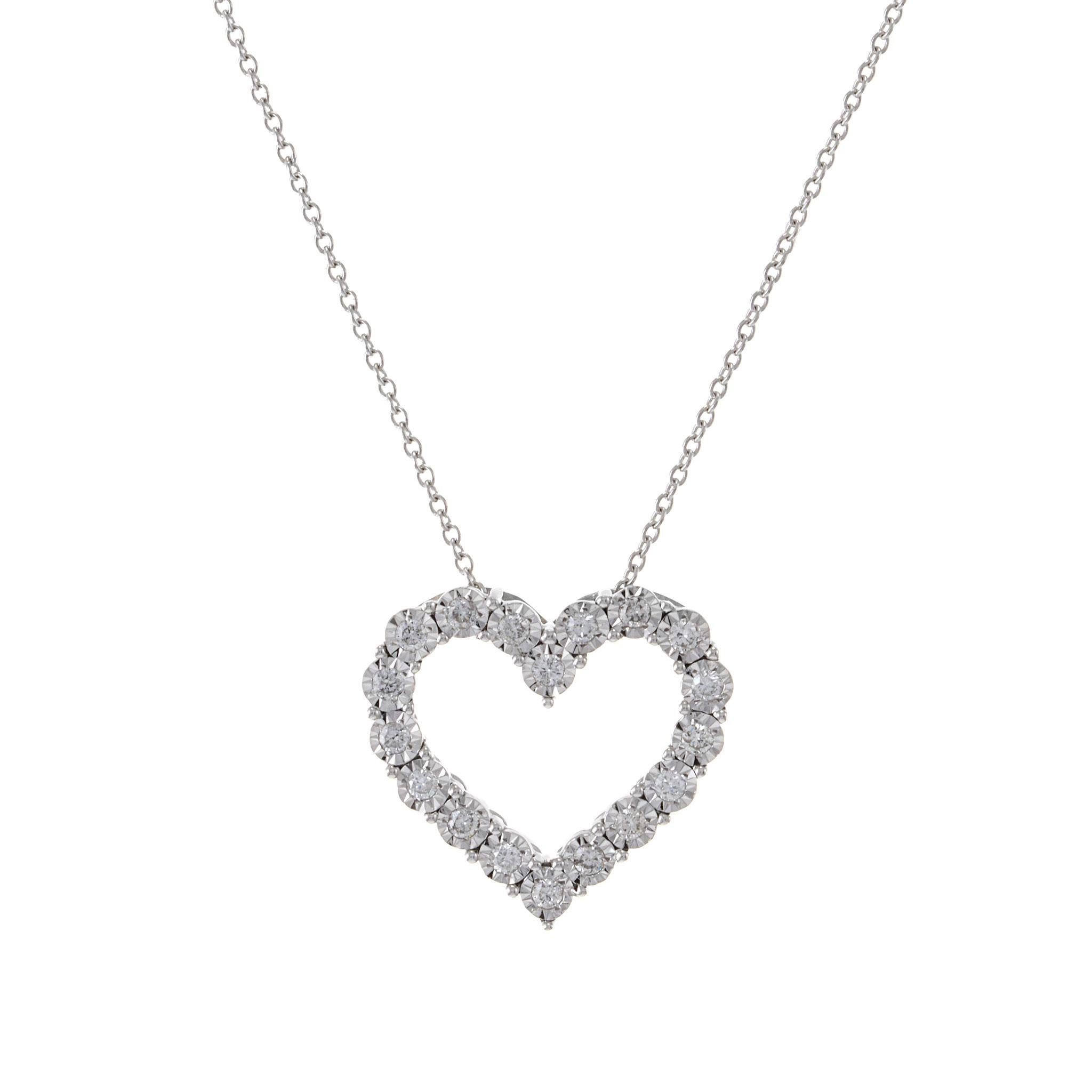 Adorna la tua scollatura con il dolce fascino di questo ciondolo a cuore aperto in oro bianco 14KT. Il ciondolo presenta un totale di 0,24 carati di diamanti rotondi taglio brillante, con colore G e purezza SI1-SI2, incastonati in una montatura a