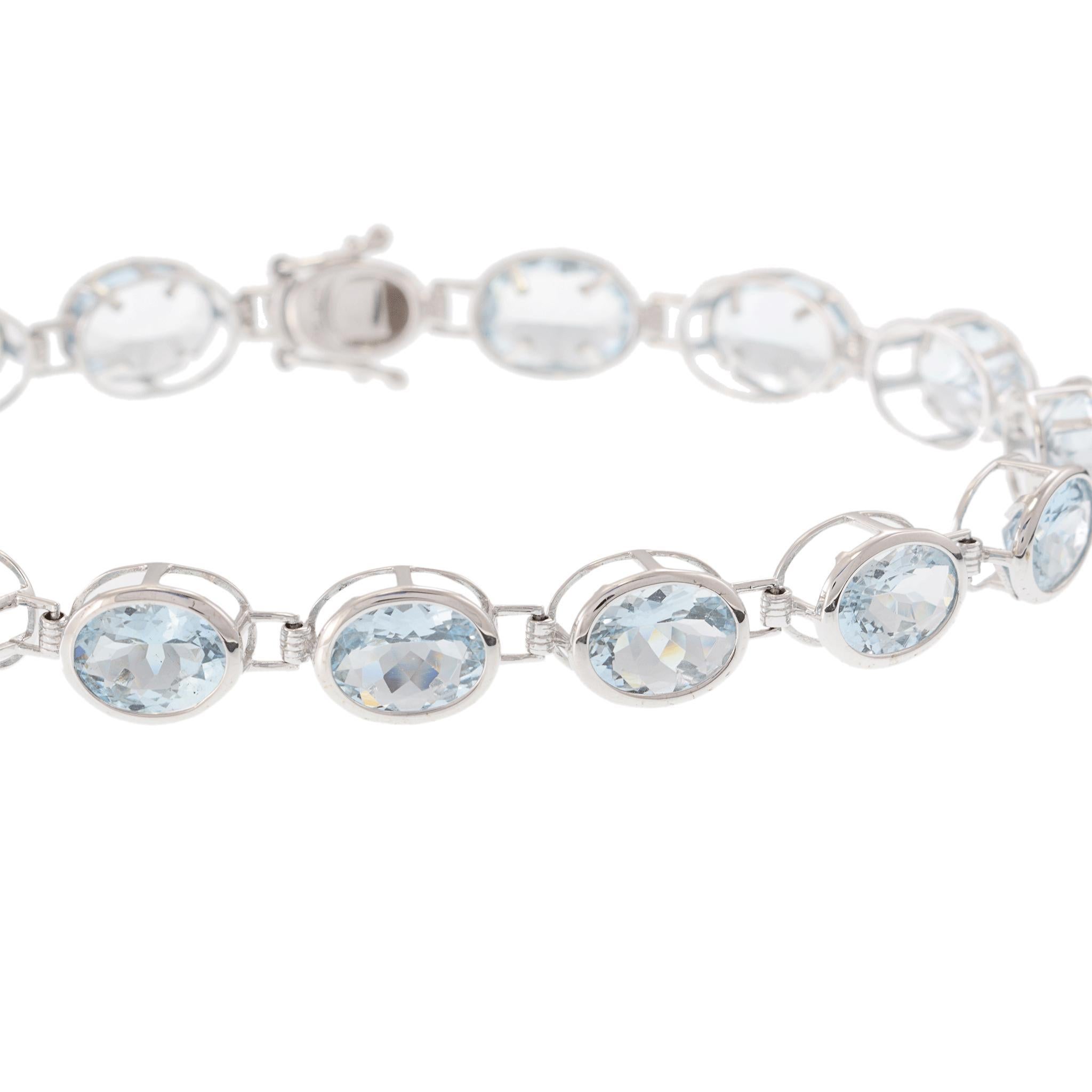 Elegante y etérea, esta pulsera de oro blanco de 14 quilates exhibe la serena belleza de la aguamarina en un engaste atemporal estilo tenis. Cada una de las gemas de talla ovalada ha sido cuidadosamente seleccionada por su gélido tono azul y su
