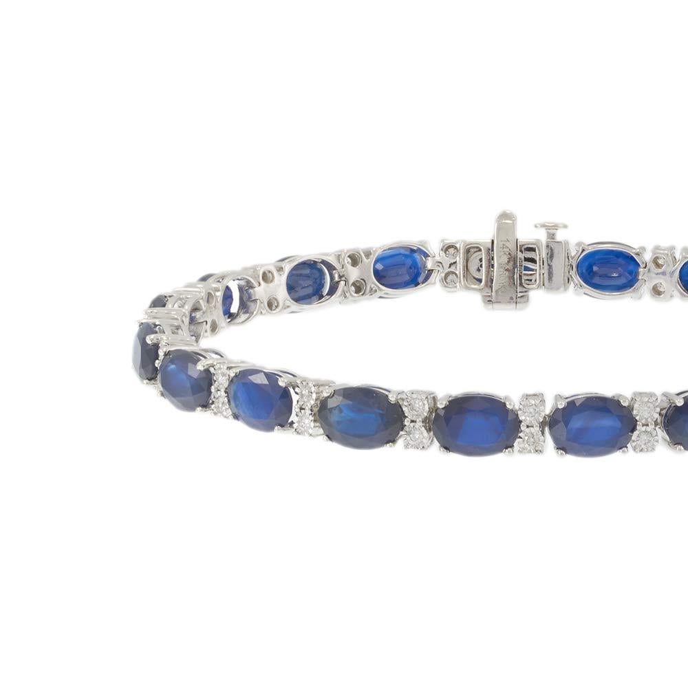 D'un design élégant et intemporel, ce bracelet présente une séquence captivante de saphirs bleus de taille ovale alternant avec des diamants ronds de taille brillant. Sertis dans de l'or blanc 14 carats, les saphirs bleus vifs sont encadrés par