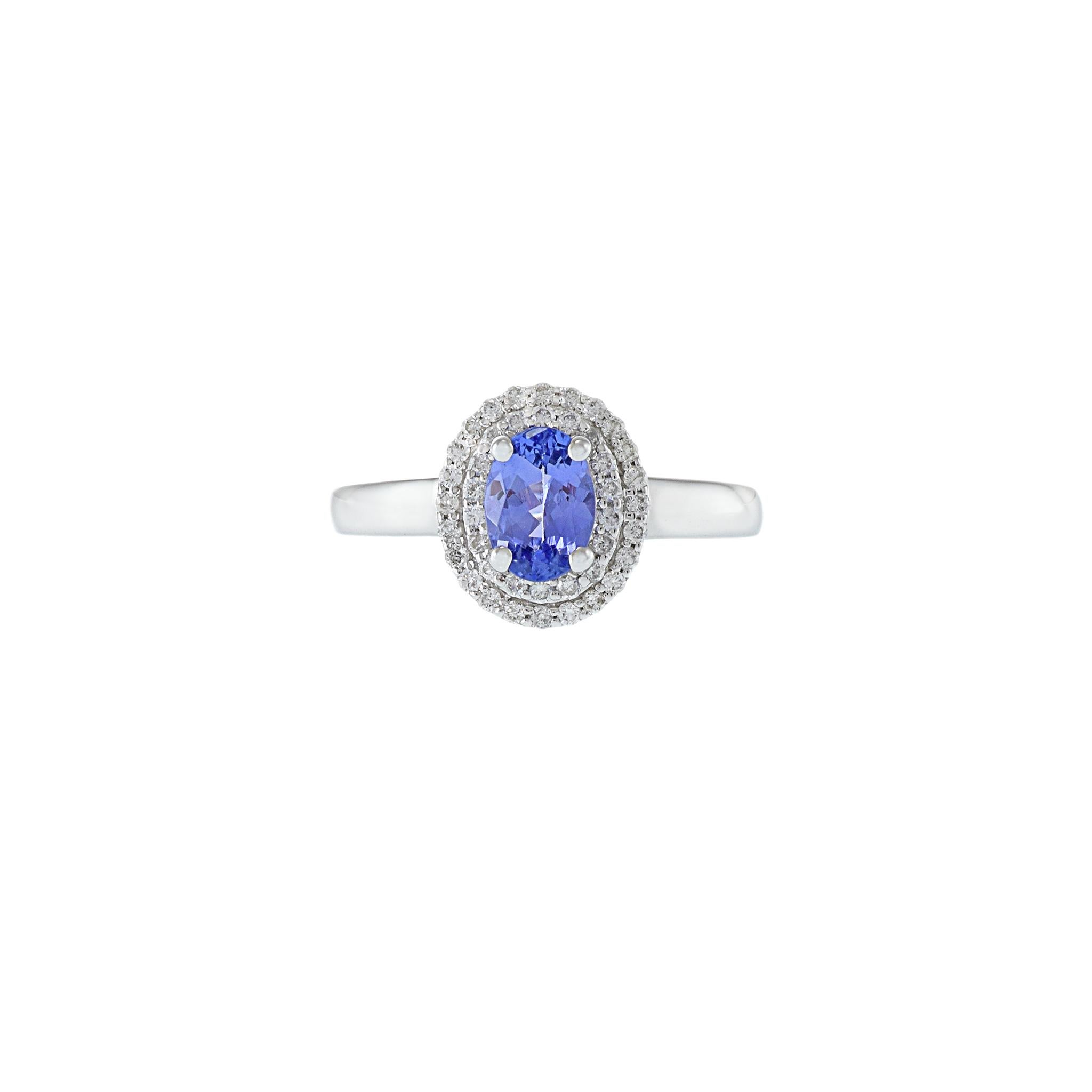 Questo anello in oro bianco 14KT è una splendida vetrina di eleganza, con una tanzanite centrale dal taglio ovale del peso di 0,78CT. La tanzanite è circondata da un doppio alone di diamanti a taglio rotondo, per un totale di 0,28 carati con colore
