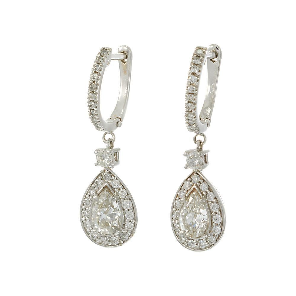 Élégamment allongées et brillamment réalisées, ces boucles d'oreilles pendantes en or blanc 14k sont ornées de deux diamants naturels en forme de poire totalisant 1,47 carats, de couleur G-H et de pureté VS. Chaque poire est entourée d'un délicat