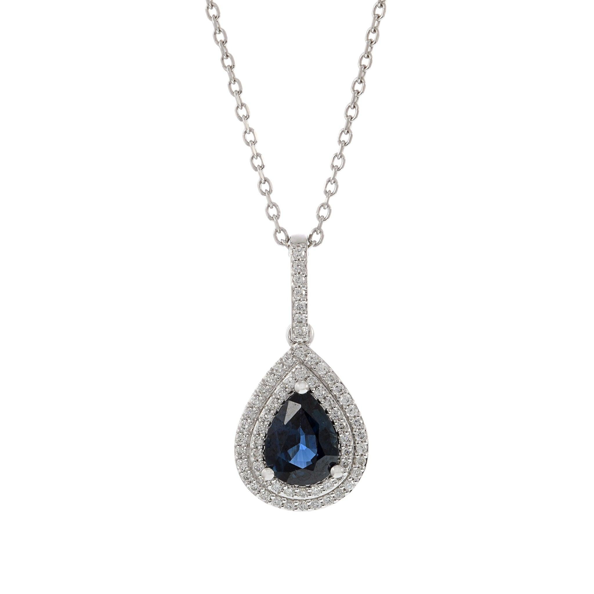 This stunning necklace features a 1.31 carat genuine pear cut blue sapphire, elegantly set in 14KT white gold. The sapphire is surrounded by 0.25 carats of round cut diamonds, creating a sparkling halo that enhances the beauty of the sapphire. This