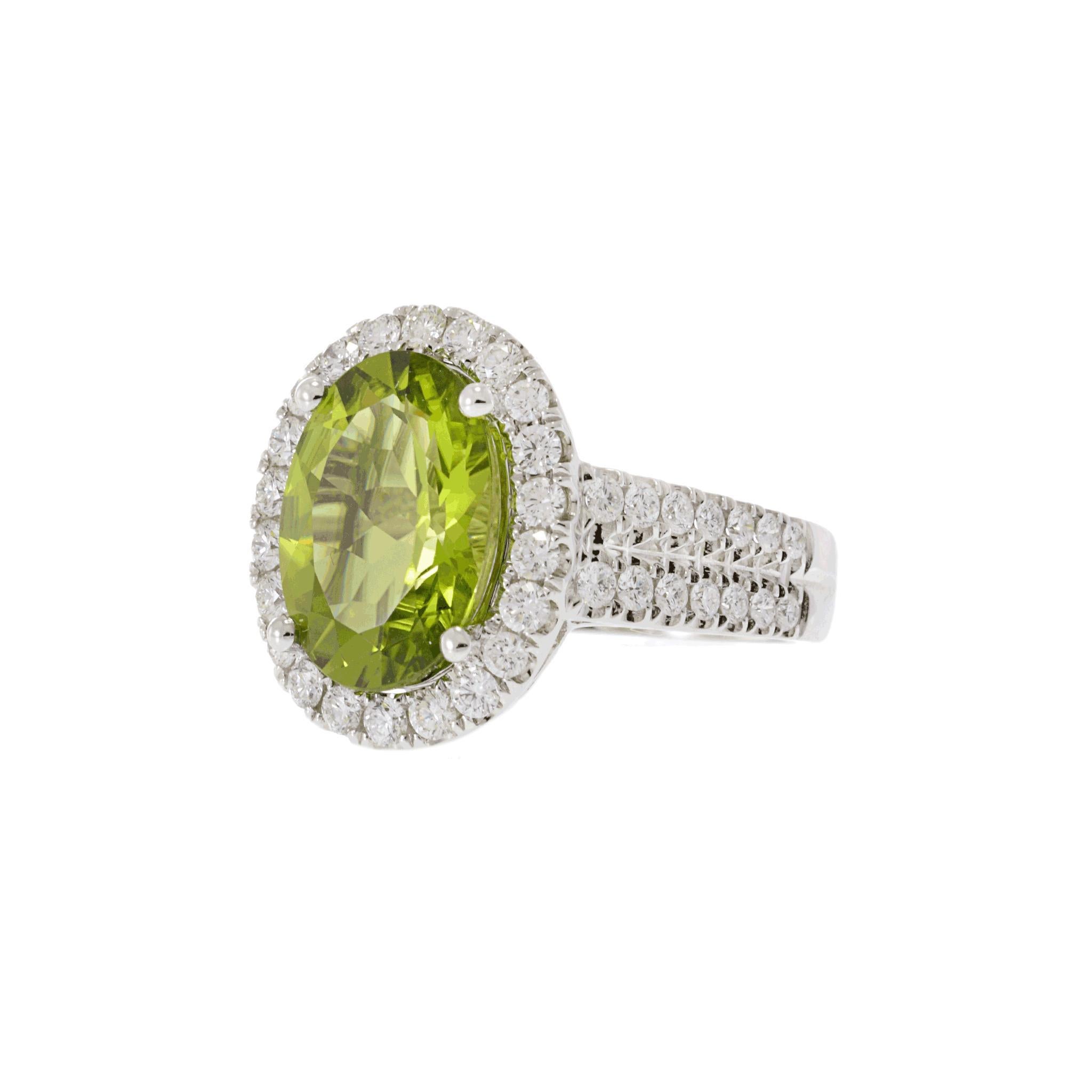 A striking Peridot and Diamond halo Ring, featuring a captivating 5.89ct Oval Green Peridot set in 14k White Gold, adorned with 1.25ct G-VS of Round White Diamonds.

Ring size adjustable.