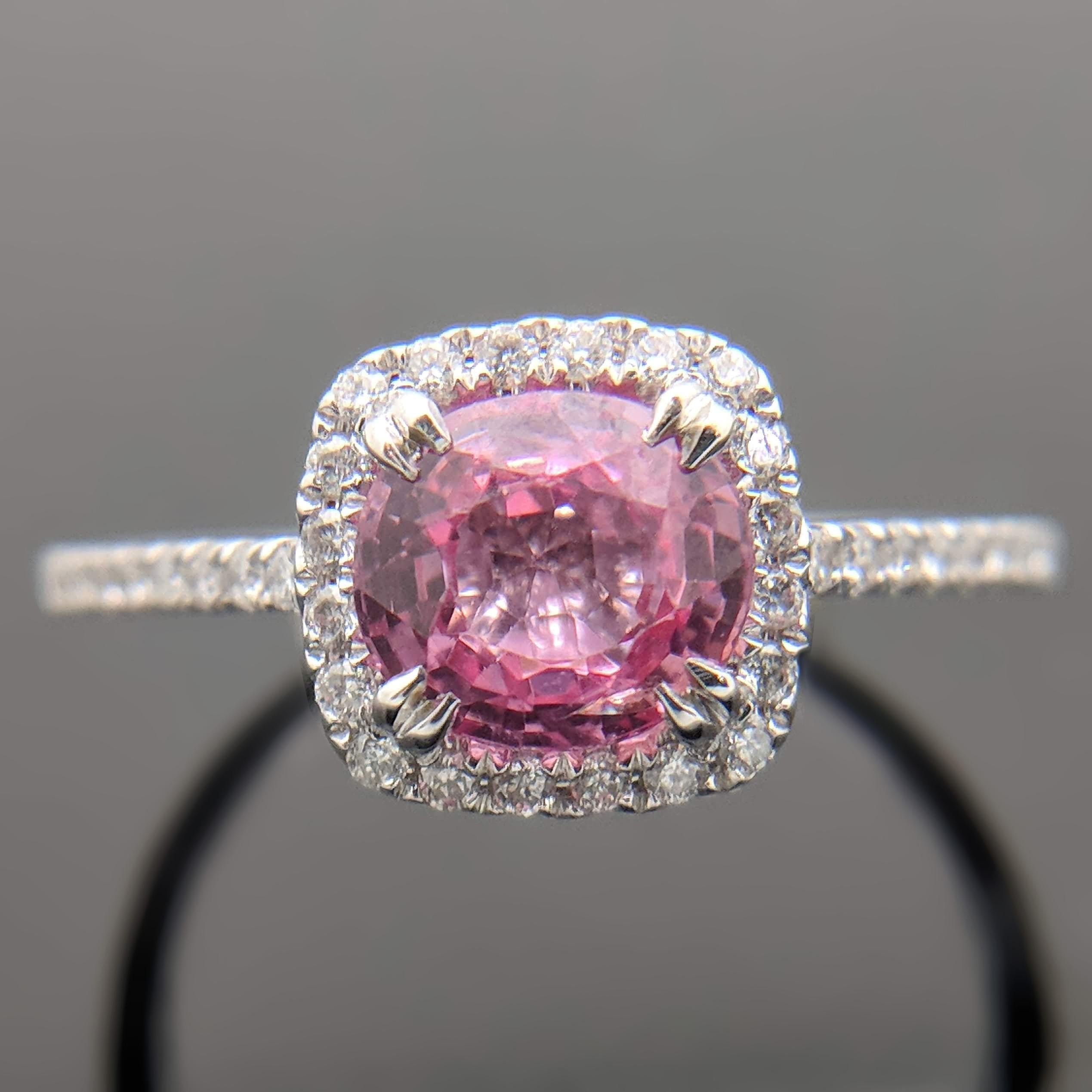 A 14kt white gold ring featuring a pink spinel estimated at 1.13ct with double prongs. The spinel is accented with a halo of diamonds as well as diamonds down the shoulders and shank with an estimated 0.18cttw. Estimated weight of gold is 1.25 gr.