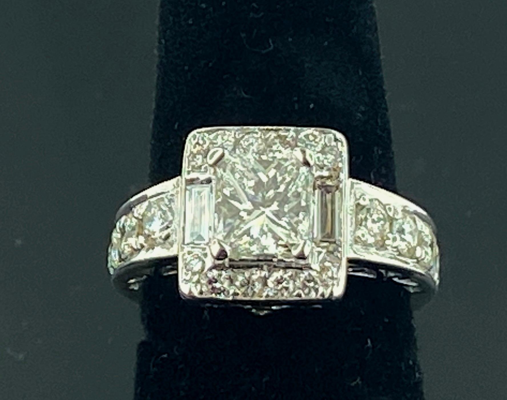 Set in 14 karat white gold, weighing 7.83 grams, is a 1.75 carat Princess Cut diamond in the center, Color Range: F-G, Clarity: VS-2, with 22 Round Brilliant Cut diamonds having a total weight of 1.25 carats and 2 Baguette Cut diamonds weighing 0.25