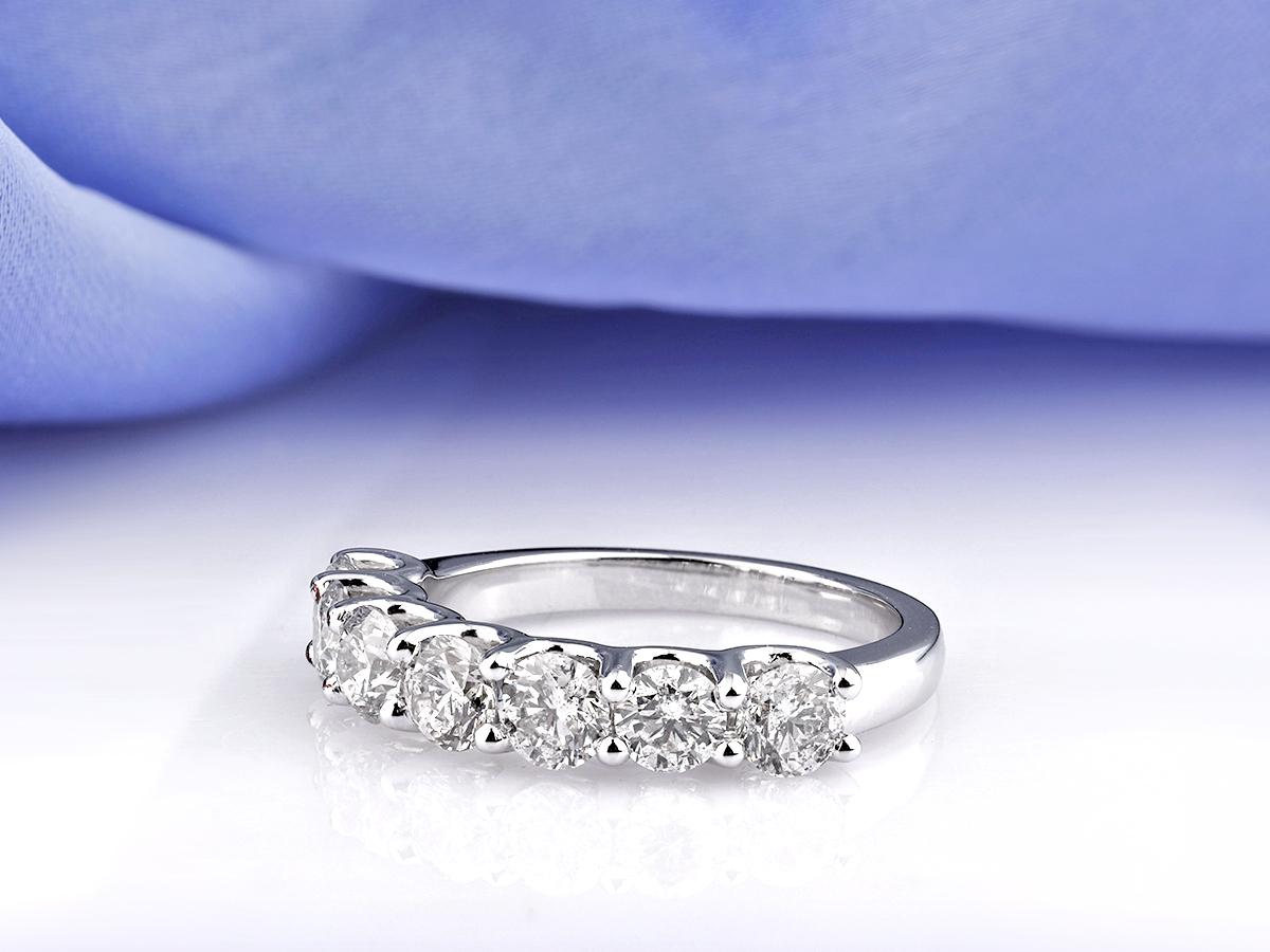 Dieser elegante Ring aus 14-karätigem Weißgold ist mit sieben funkelnden runden Diamanten im Brillantschliff besetzt, die in einem zeitlosen Design mit halber Ewigkeit gefasst sind. Jeder Diamant ist sorgfältig gefasst, um die Brillanz und das