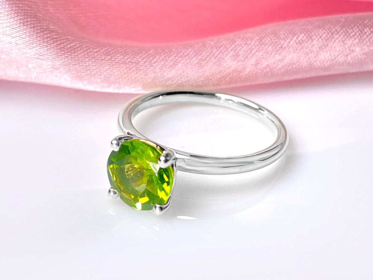 Er zeigt ein zeitloses Solitär-Design, bei dem ein einzelner Peridot-Stein von einer Vier-Zacken-Fassung sicher gehalten wird. Dieser Stil maximiert die Lichteinstrahlung auf den Edelstein, wodurch sein natürlicher Glanz verstärkt wird.

MATERIAL : 
