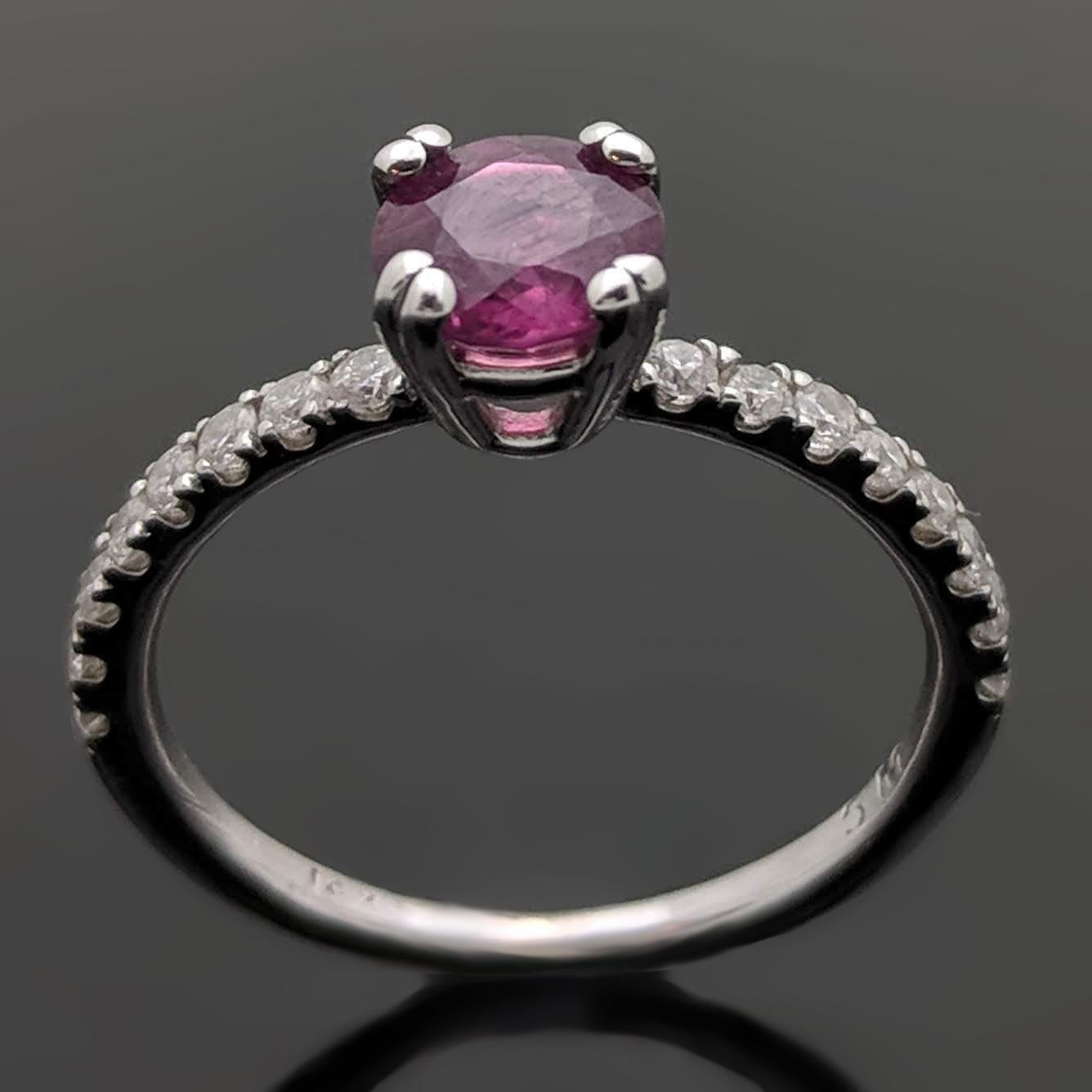 14kt white gold ring featuring a gorgeous ruby estimated at 0.75ct and accent diamonds estimated at 0.11cttw down the shoulders. Estimated weight of gold is 1 gr. 

We will size it for you.

