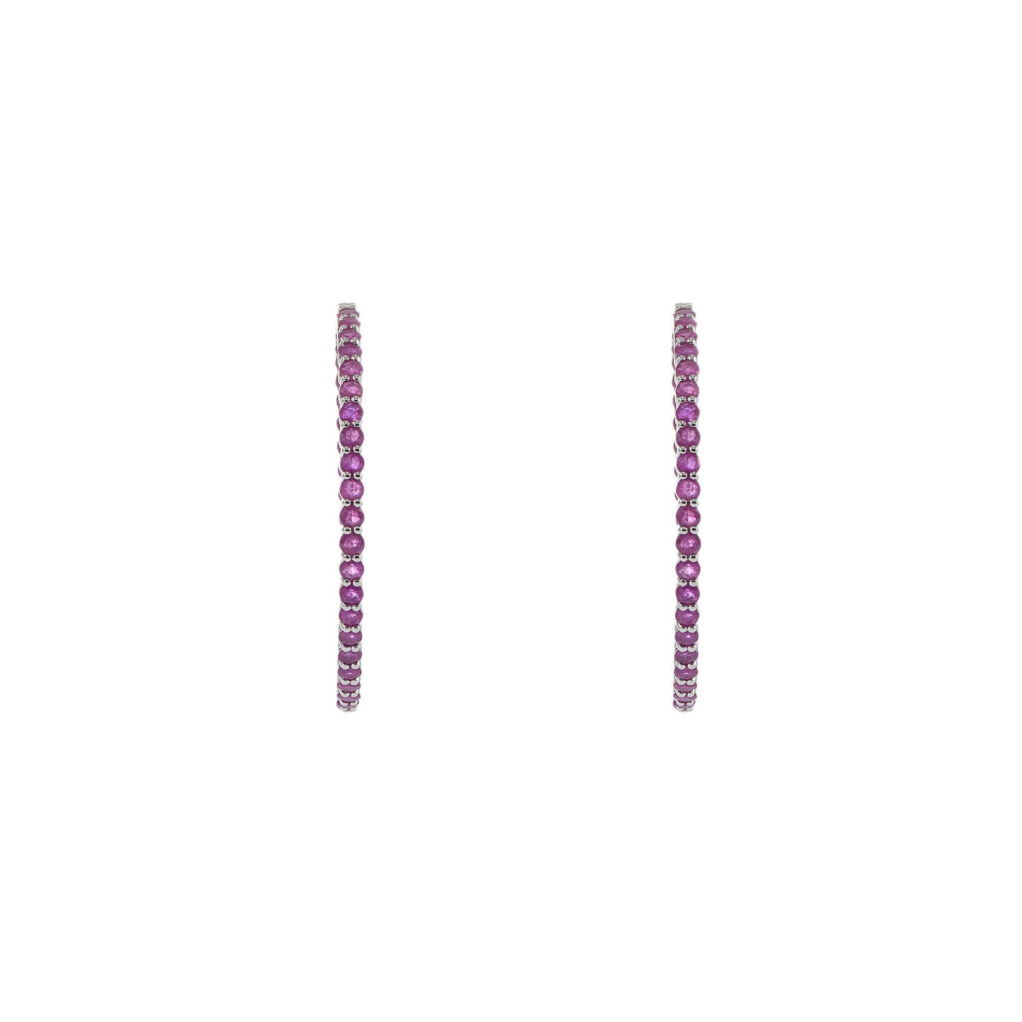 Estos llamativos pendientes de aro entrante y saliente de oro blanco de 14 quilates presentan un total de 6,01 quilates de rubíes talla redonda. El vibrante tono rojo de los rubíes crea un diseño cautivador y lujoso, haciendo de estos pendientes un