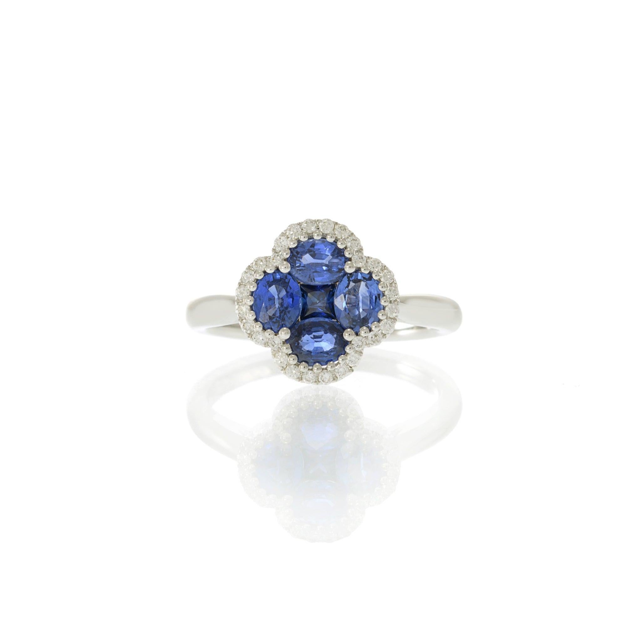 Questo affascinante anello in oro bianco 14KT presenta un design ispirato a un fiore con quattro zaffiri colorati per un totale di 1,37 carati. Gli zaffiri formano un motivo floreale simile a un trifoglio, circondato da una delicata aureola di