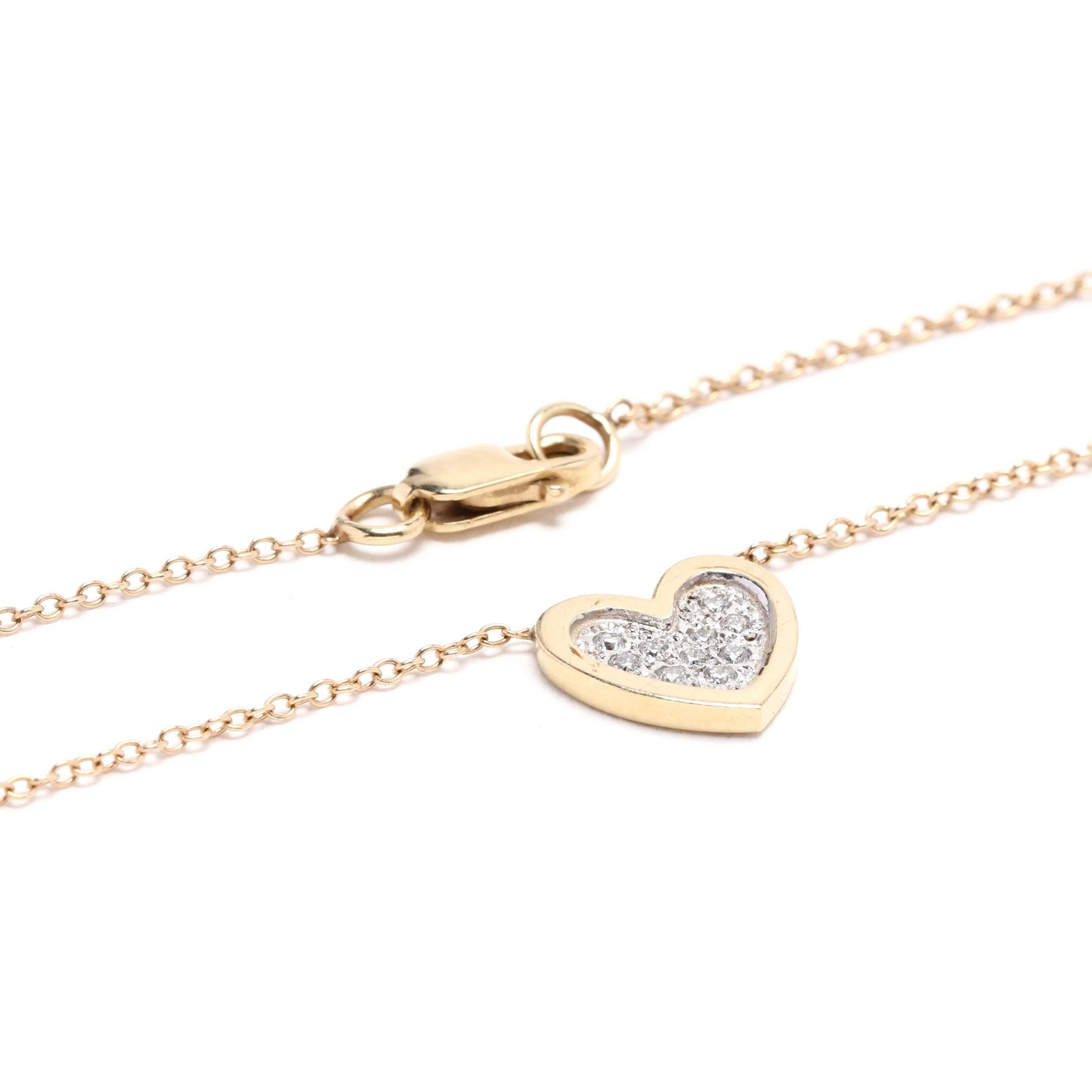 14k yellow and white gold diamond heart necklace. A timeless symbol of love, this necklace is a classic cable with a heart-shaped pendant. The pendant has a yellow gold edge and the center features diamonds set in white gold. This would make a great