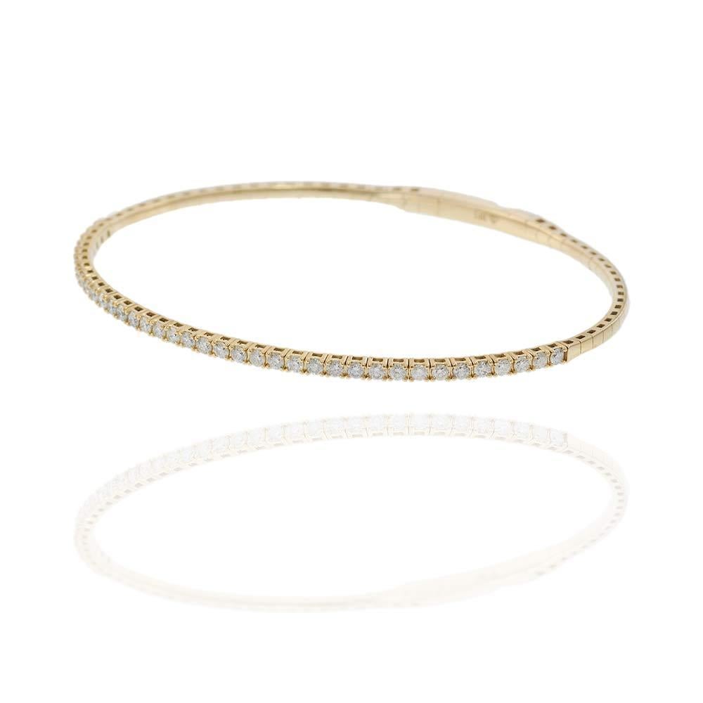 Radiating brilliance and warmth, this 14KT yellow gold flex bangle is adorned with a full carat of round brilliant diamonds, delicately arranged in a continuous row for maximum sparkle. Its flexible construction provides an easy, secure fit while