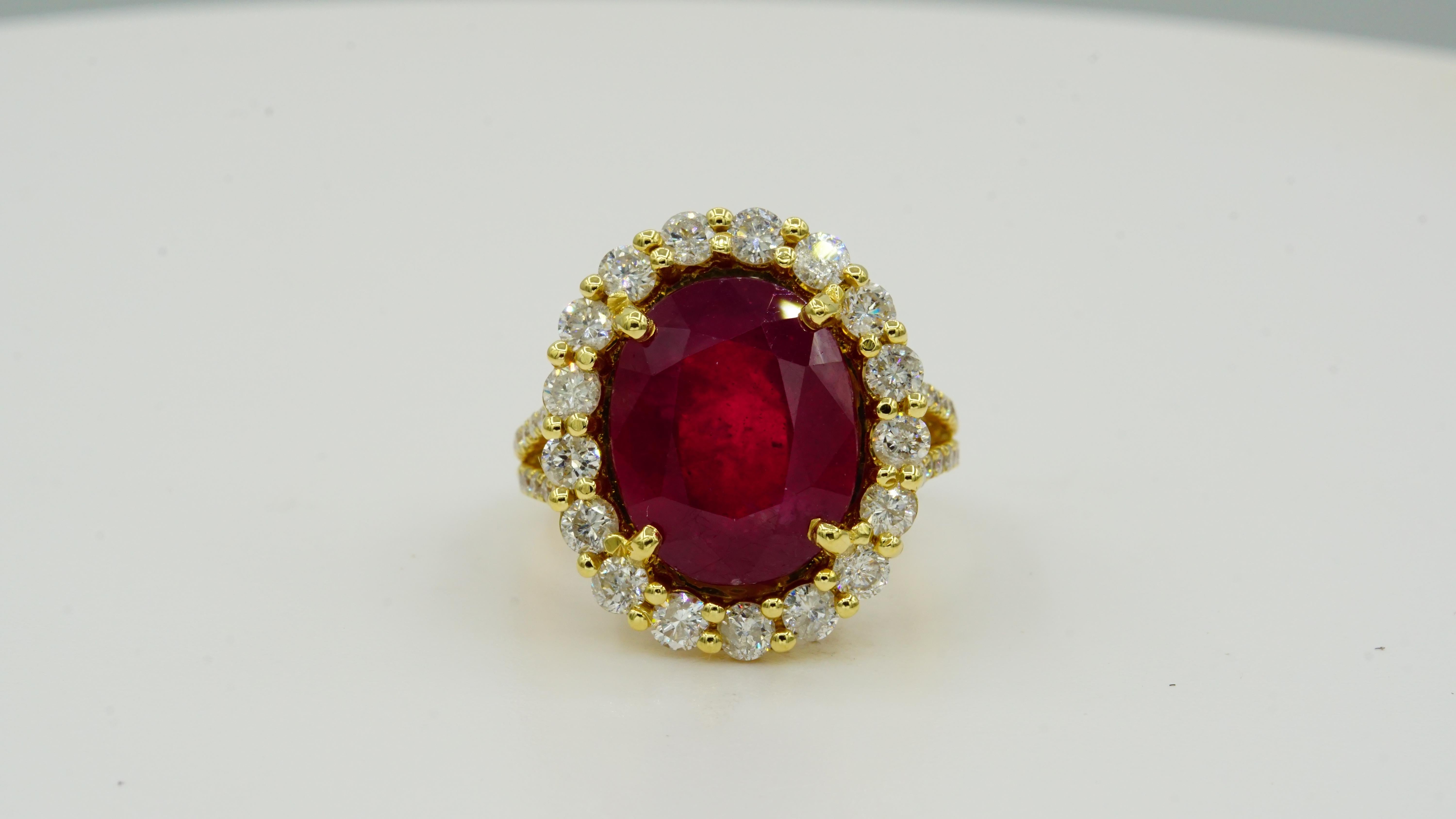 This stunning ring is crafted from 14kt yellow gold and features a breathtaking 10.90 ct oval natural ruby. It is accented by fifty-three prong-set round brilliant diamonds that total 1.67 ct in weight. The ruby measures 14 x 11.20 x 7.30 mm,