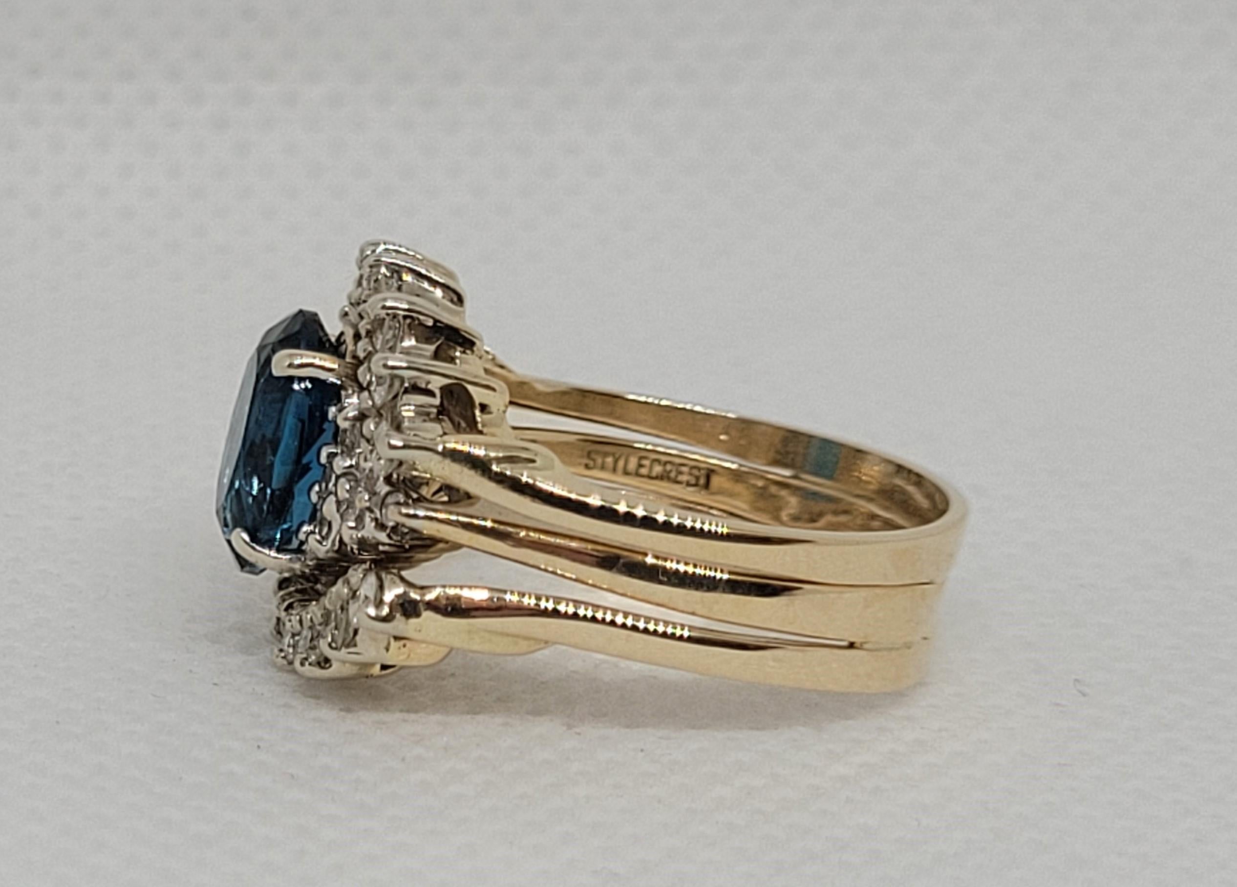 This exquisite ladies' ring is crafted from 14kt yellow gold and features a stunning 9x7 oval blue topaz with an attached diamond ring wrap. The blue topaz exhibits a beautiful and captivating blue hue, with very light abrasion from wear that is