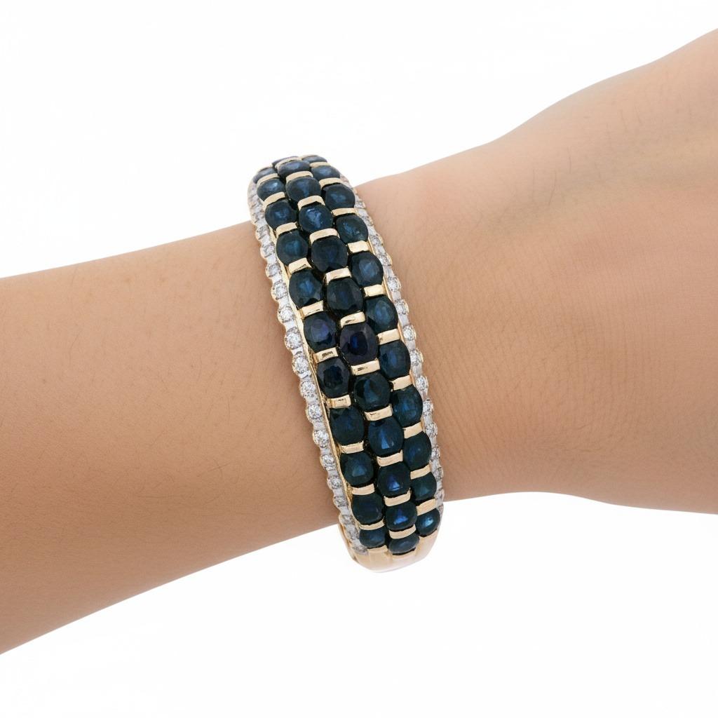 Esta exquisita pulsera de oro amarillo de 14 quilates está bellamente engastada con 31 zafiros azules de talla ovalada que suman aproximadamente 12,40 quilates, mostrando vibrantes y ricos matices azules que cautivan la vista. Como complemento de