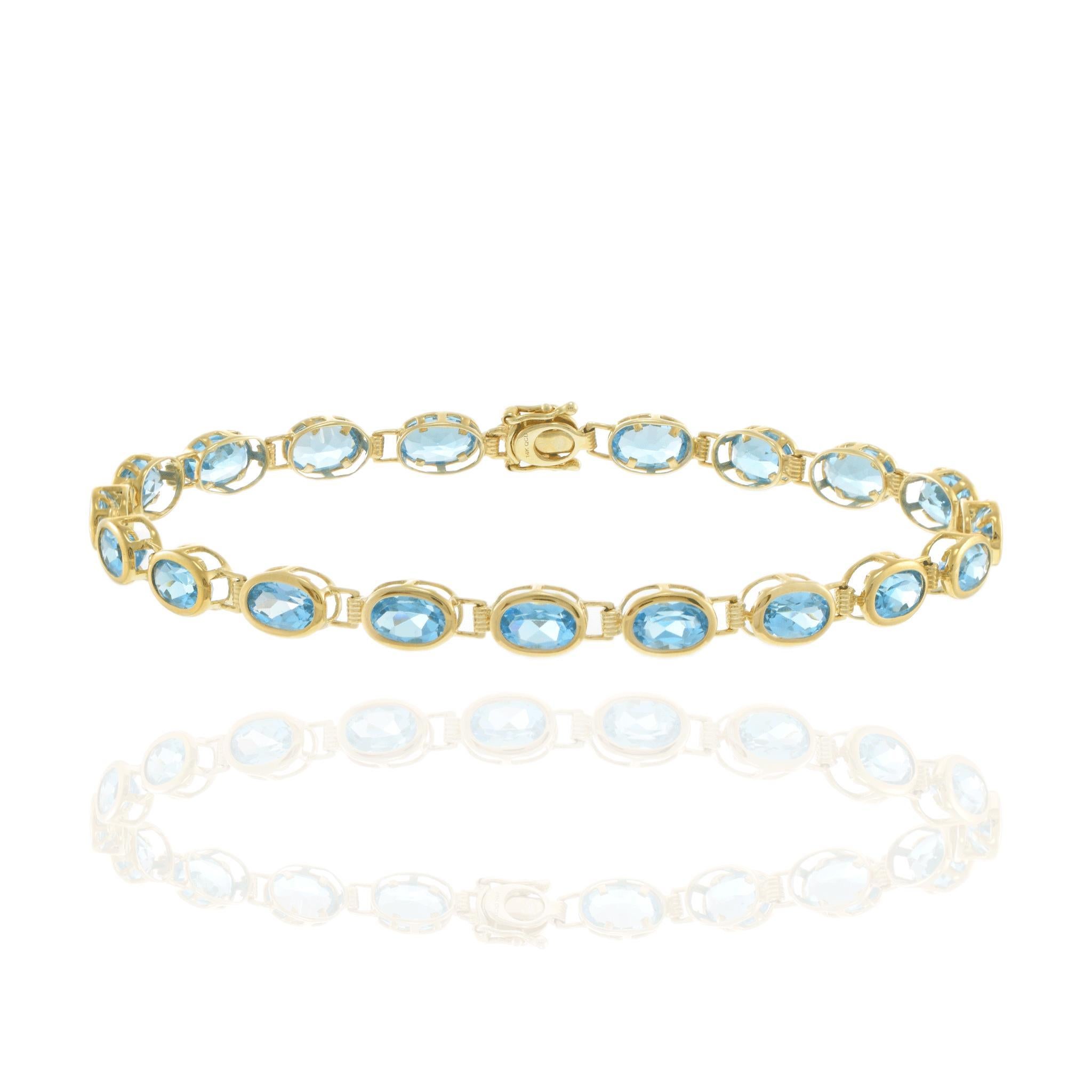 Elegamment réalisé en or jaune 14k, ce bracelet met en valeur une étonnante série de pierres de topaze bleue de taille ovale. Chaque pierre précieuse est méticuleusement sertie, ce qui met en valeur sa teinte bleue vibrante. Le design du bracelet