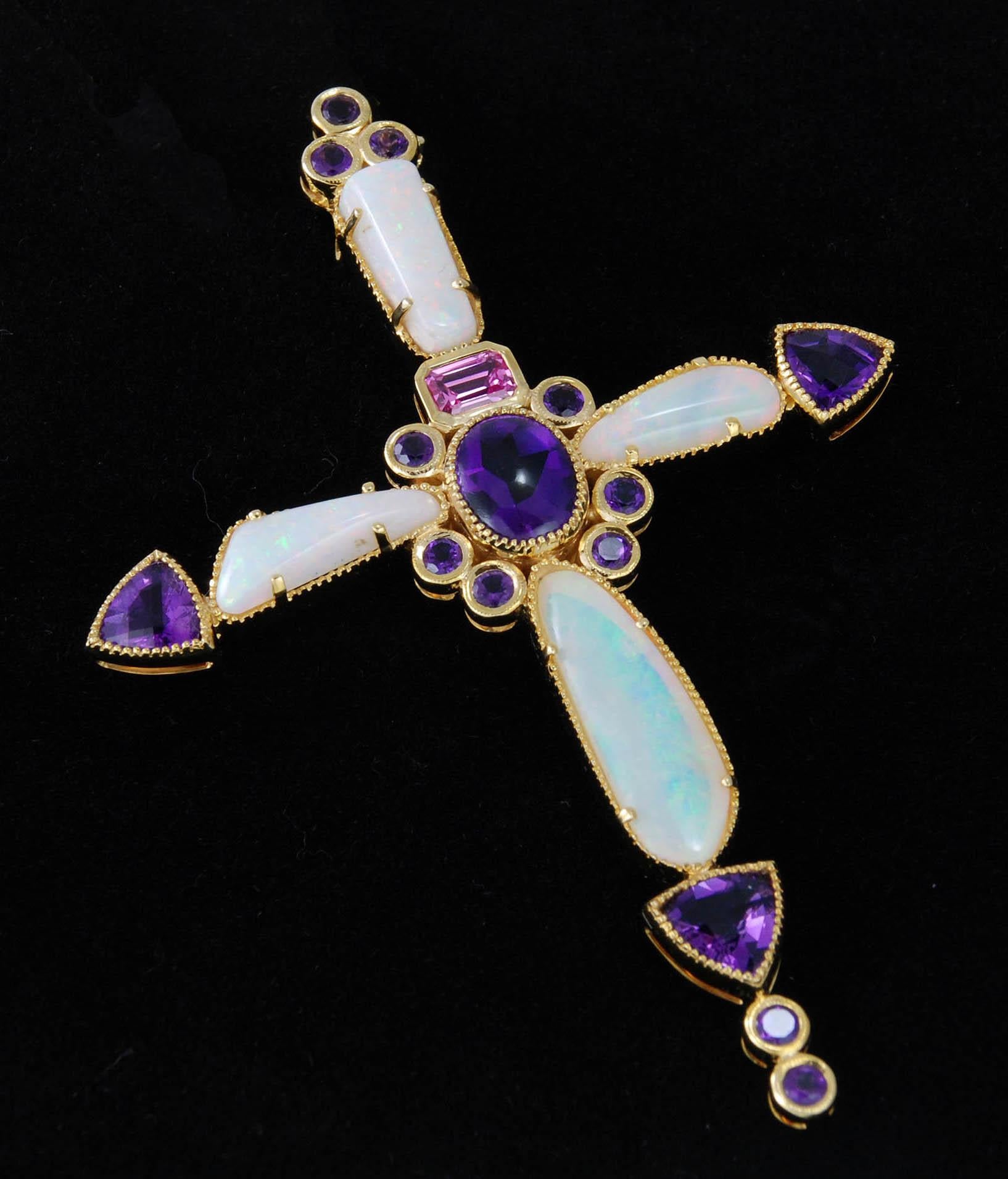 A 14kt Yellow Gold Bejeweled Bishop's Cross Pendant set with 4 pieces of Australian White Opal totaling 11.4 Carats, 15 pieces of Amethyst totaling 7.43 Carats cut in Rounds, Trillions and a central Cabochon.  Accented with a 0.79 Carat Pink