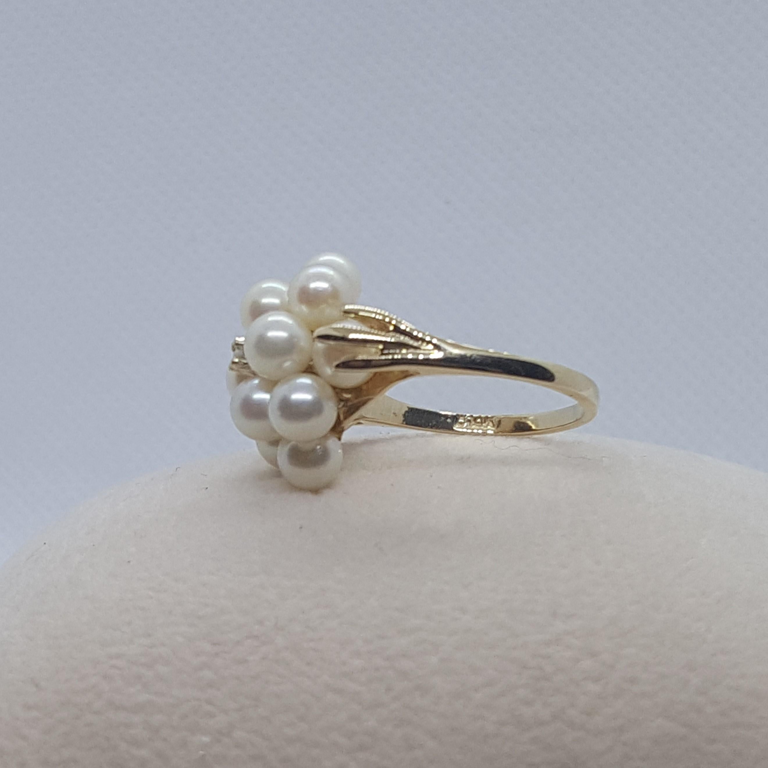 Lovely 14kt yellow gold cathedral style ring that has 12 - 4.8mm white pearls with clean lustrous nacre, accented with one single cut diamond that is approximately .02ct.  The ring is size 6.75, 5.2 grams in weight, stamped 14kt, and in very good
