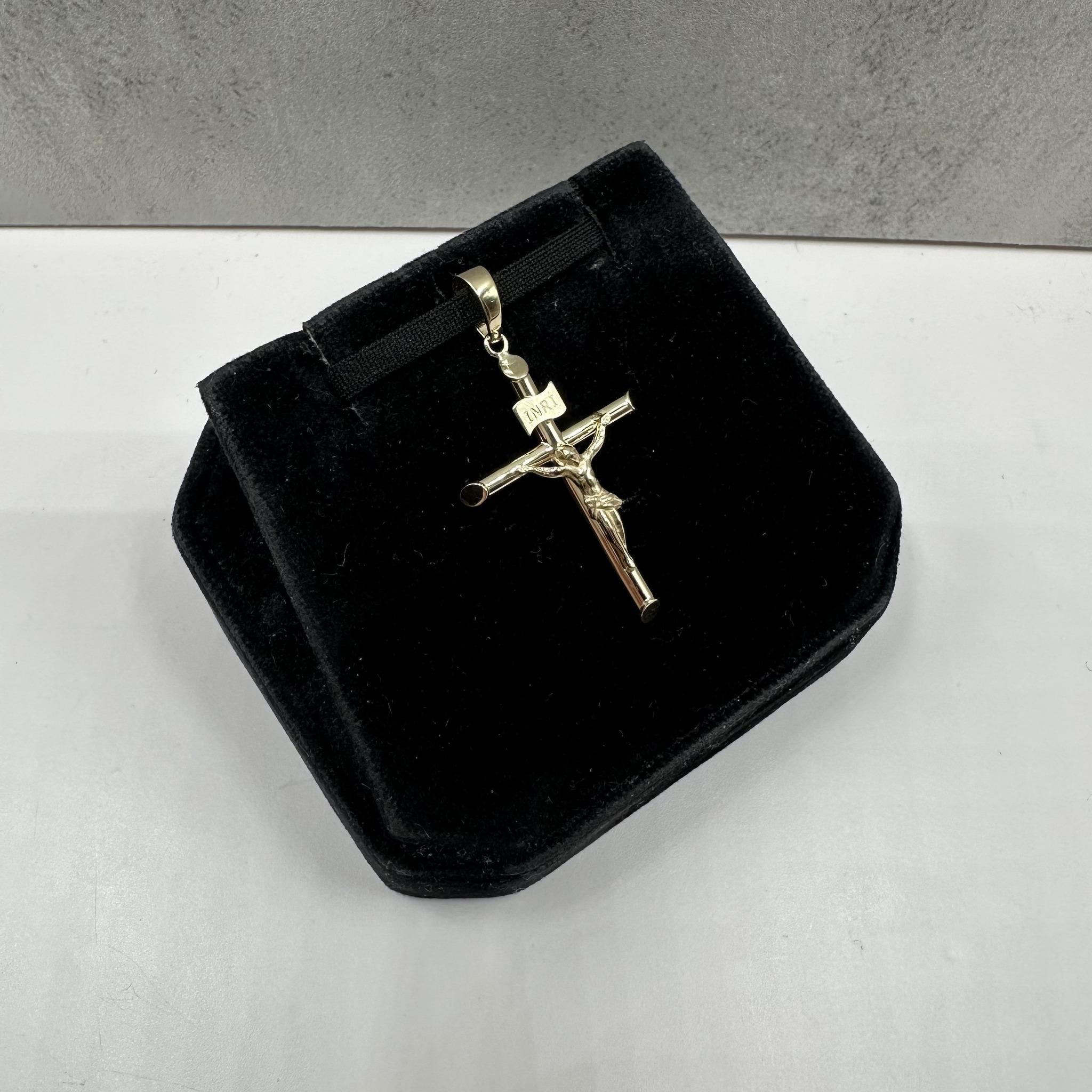 Ce pendentif crucifix en or jaune 14kt est creux, ce qui lui confère à la fois durabilité et légèreté. Avec un poids de seulement 1,5 gramme, il est parfait pour une utilisation quotidienne. La bague s'adapte à une petite chaîne, ce qui ajoute de la