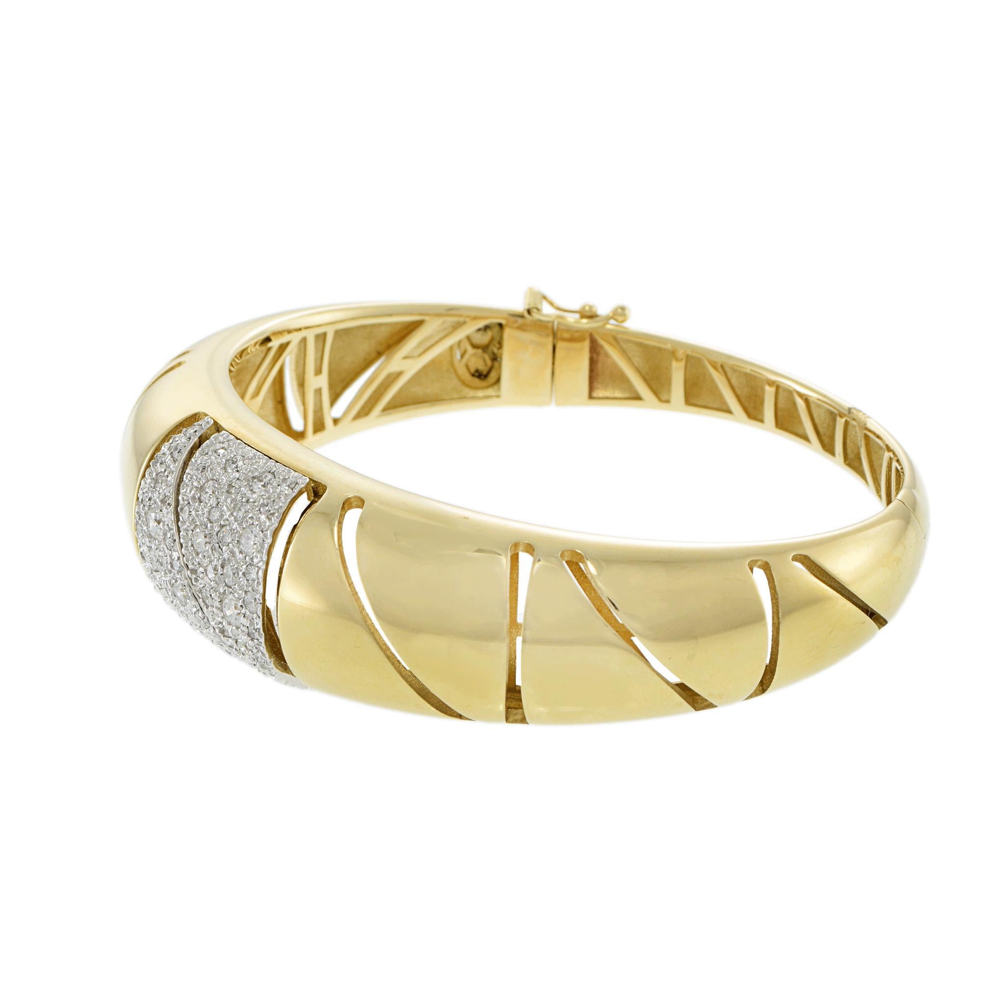 Dieser kühne Armreif aus 14 Kt. Gelbgold zeichnet sich durch ein geometrisches Muster aus, das durch eine zentrale Platte mit runden Brillanten von insgesamt 1,13 Karat hervorgehoben wird. Der Kontrast aus geschliffenem Gold und pavégefassten