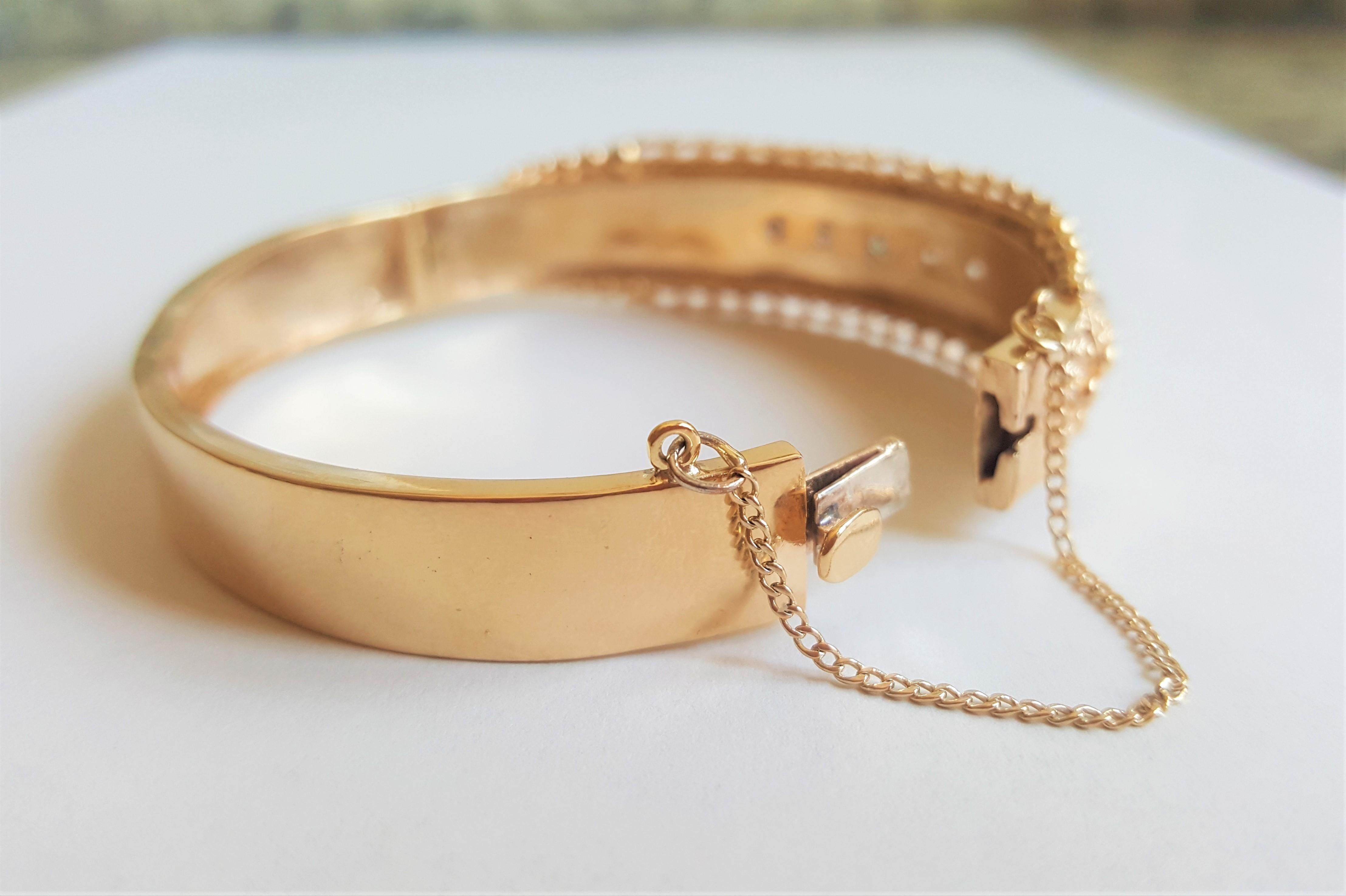 Unique 14kt yellow gold bangle bracelet with 5 diamonds of approximately .50cttw. The bracelet is 66mm x 56mm in diameter and 16mm in width secured with a push-in clasp and safety chain. The weight of the bracelet is 32.1 grams and the finish is