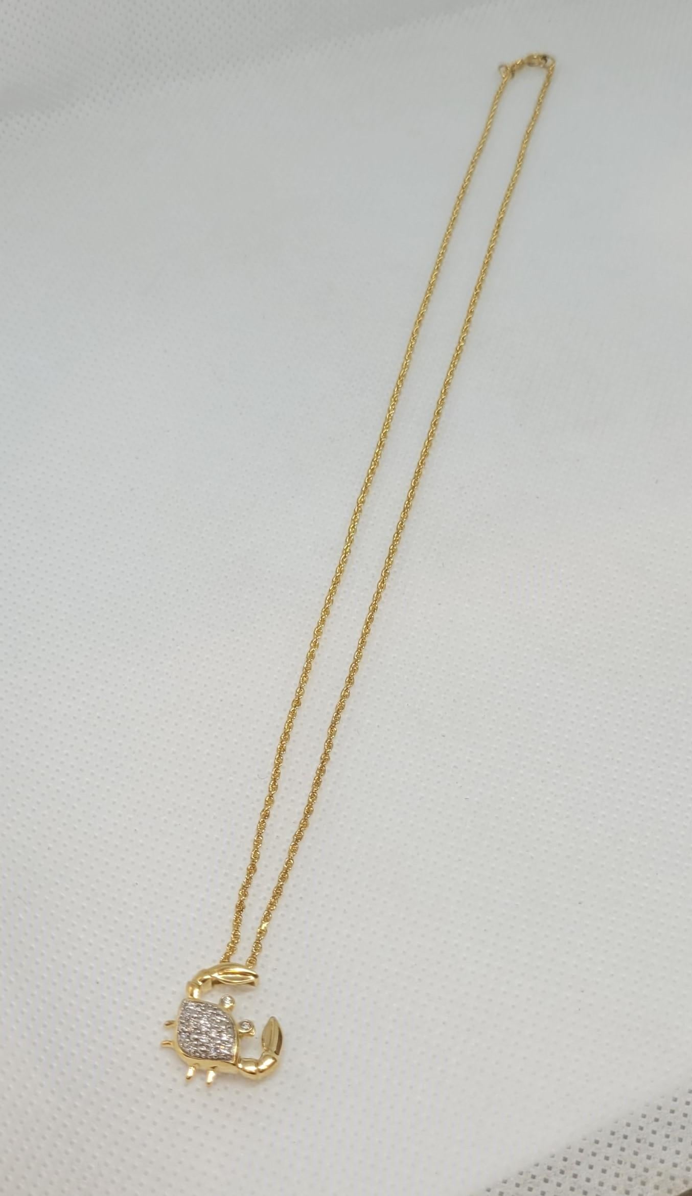 Pendente a forma di granchio in oro giallo 14 carati con 16 diamanti tondi brillanti per un peso totale di circa 0,20 carati. I diamanti hanno un colore F/G, una purezza VS/SI e sono incastonati in oro bianco per esaltarne il candore. Il ciondolo