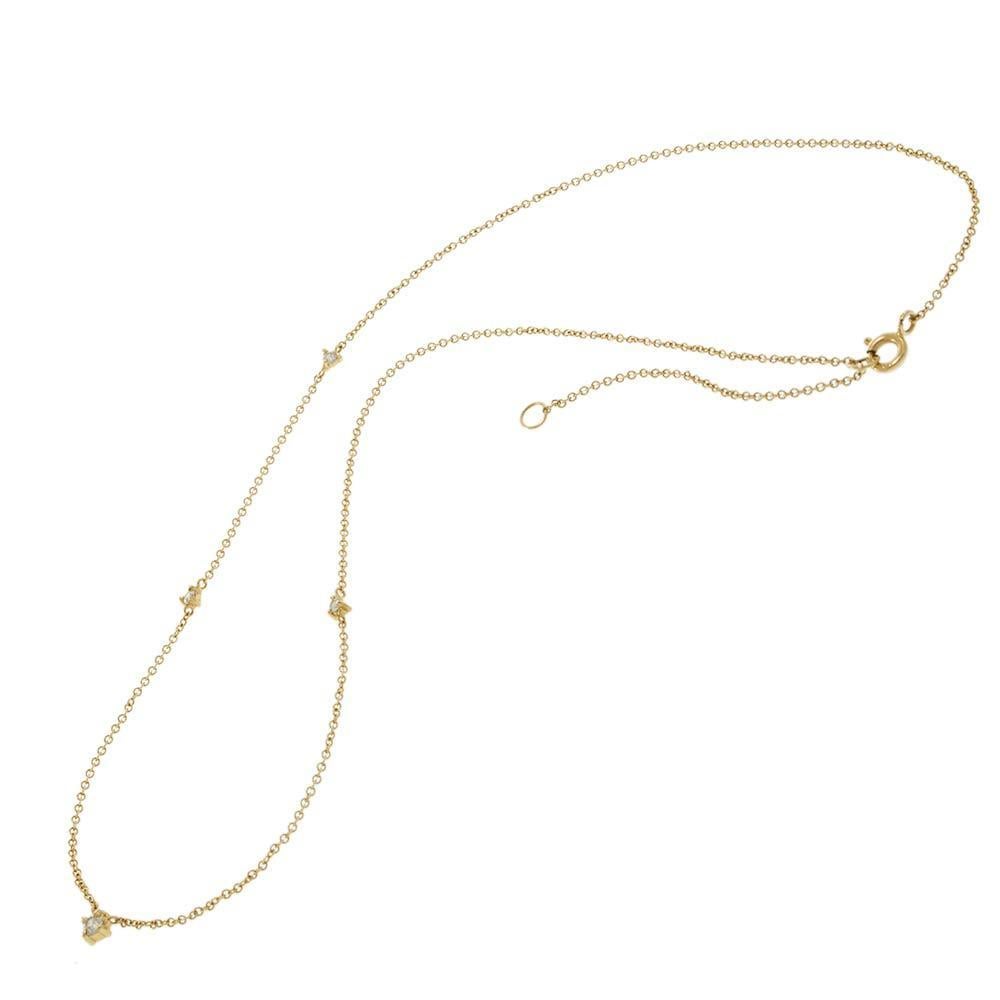 Ce collier moderne et délicat présente cinq petits diamants sertis le long d'une fine chaîne en or jaune 14KT. La pierre centrale est un diamant brillant de taille ronde encadré dans un serti triangulaire unique, créant un point focal géométrique.