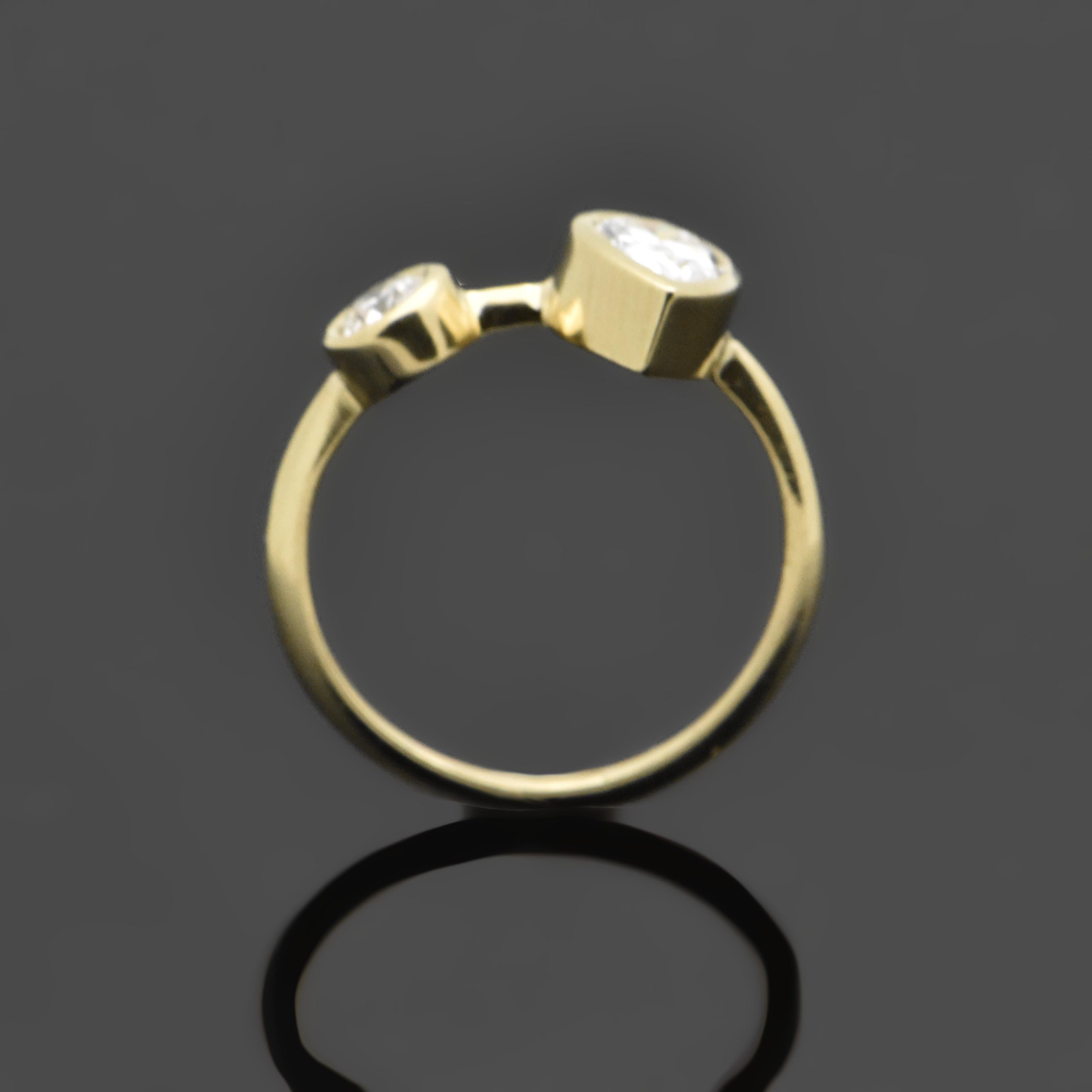 14kt Yellow Gold Diamonds Ring. This setting features a duo of unique bezel set diamonds; one round brilliant cut and one pear cut set onto a delicate yellow gold band. 

This item is a custom order only. Price is for the ring setting only. The