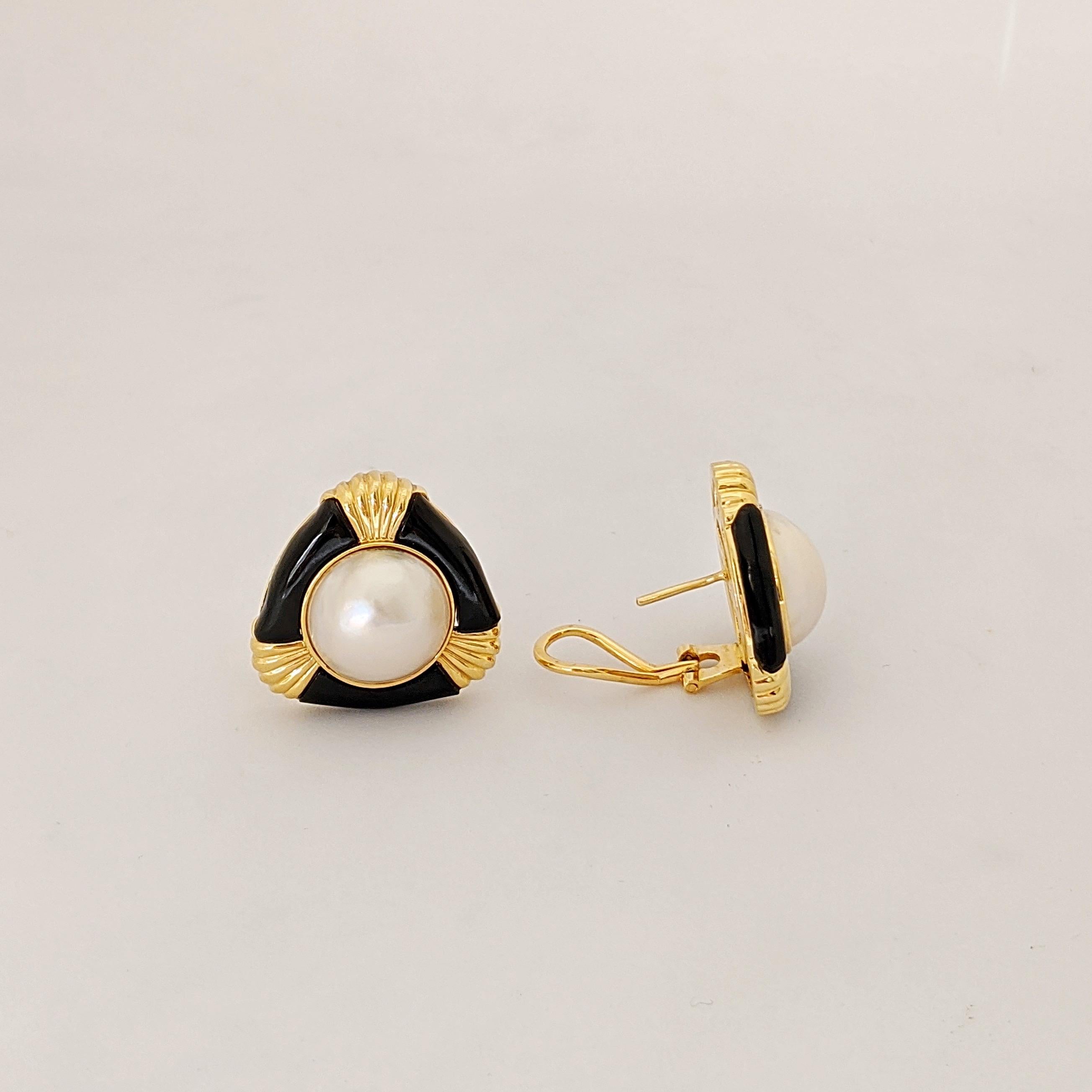 This Retro earring centers a Mabe Pearl accented with Black Onyx and 14 karat yellow gold. The triangular shaped earring measures approximately 1