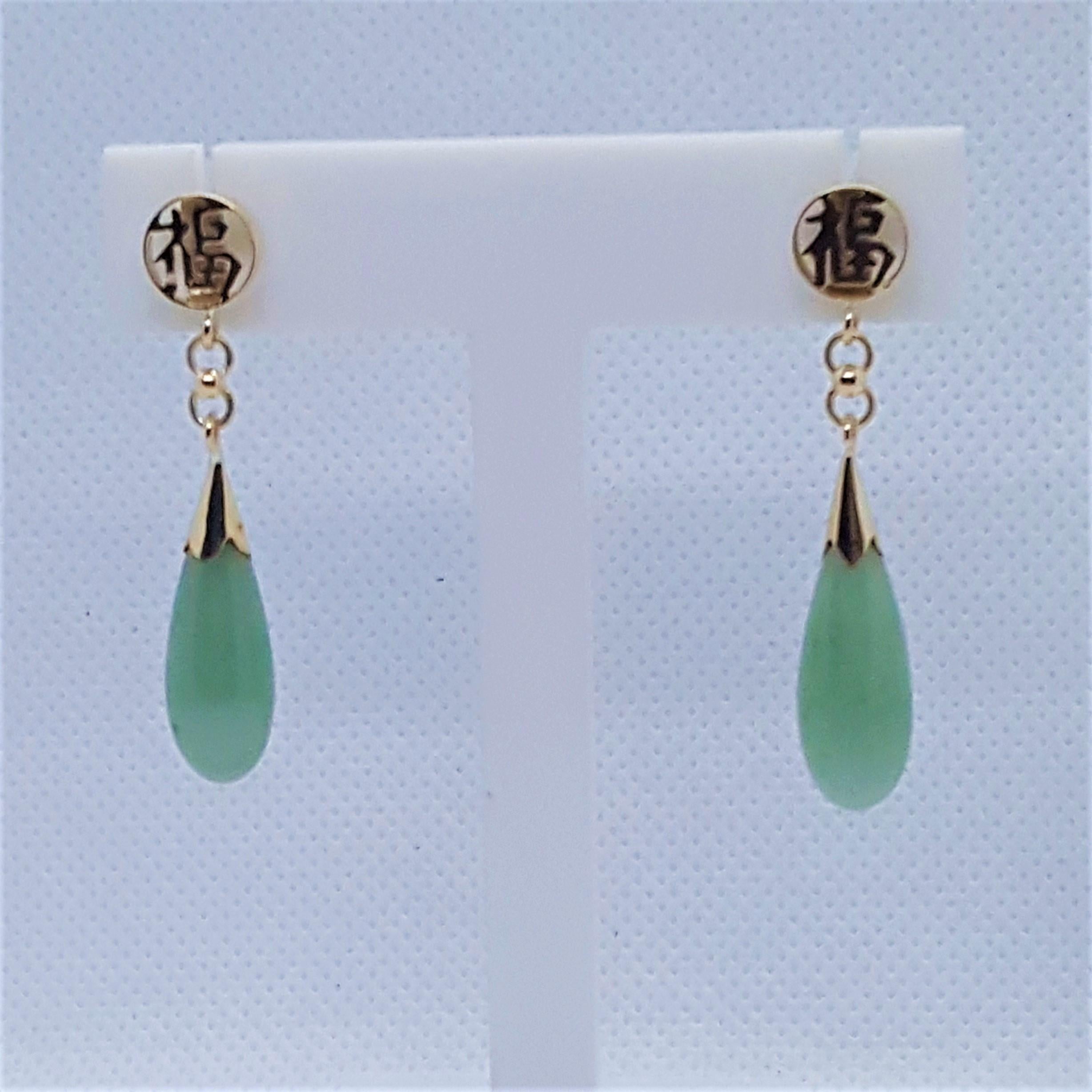 Lovely 14kt yellow gold friction post light green jade earrings with an Asian design. These earrings are in excellent condition, 6.4 grams total in weight, and appear hardly worn and like new. The diameter of the round Asian design and the widest