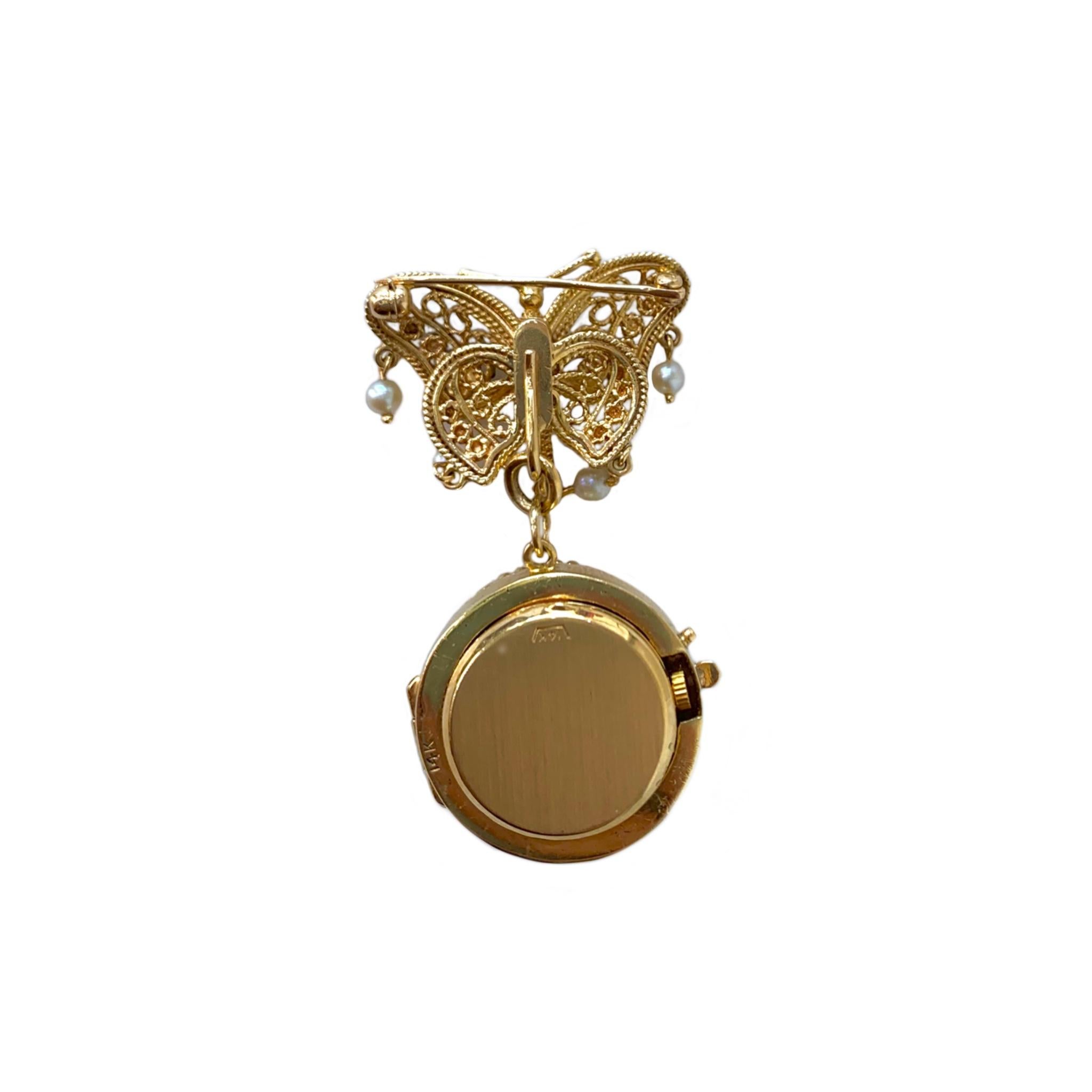 The 14 karat yellow gold brooch has a detachable hand painted miniature. The butterfly contains 14 pearls and may be worn alone. The movement has been converted to Swiss quartz for convenience. 