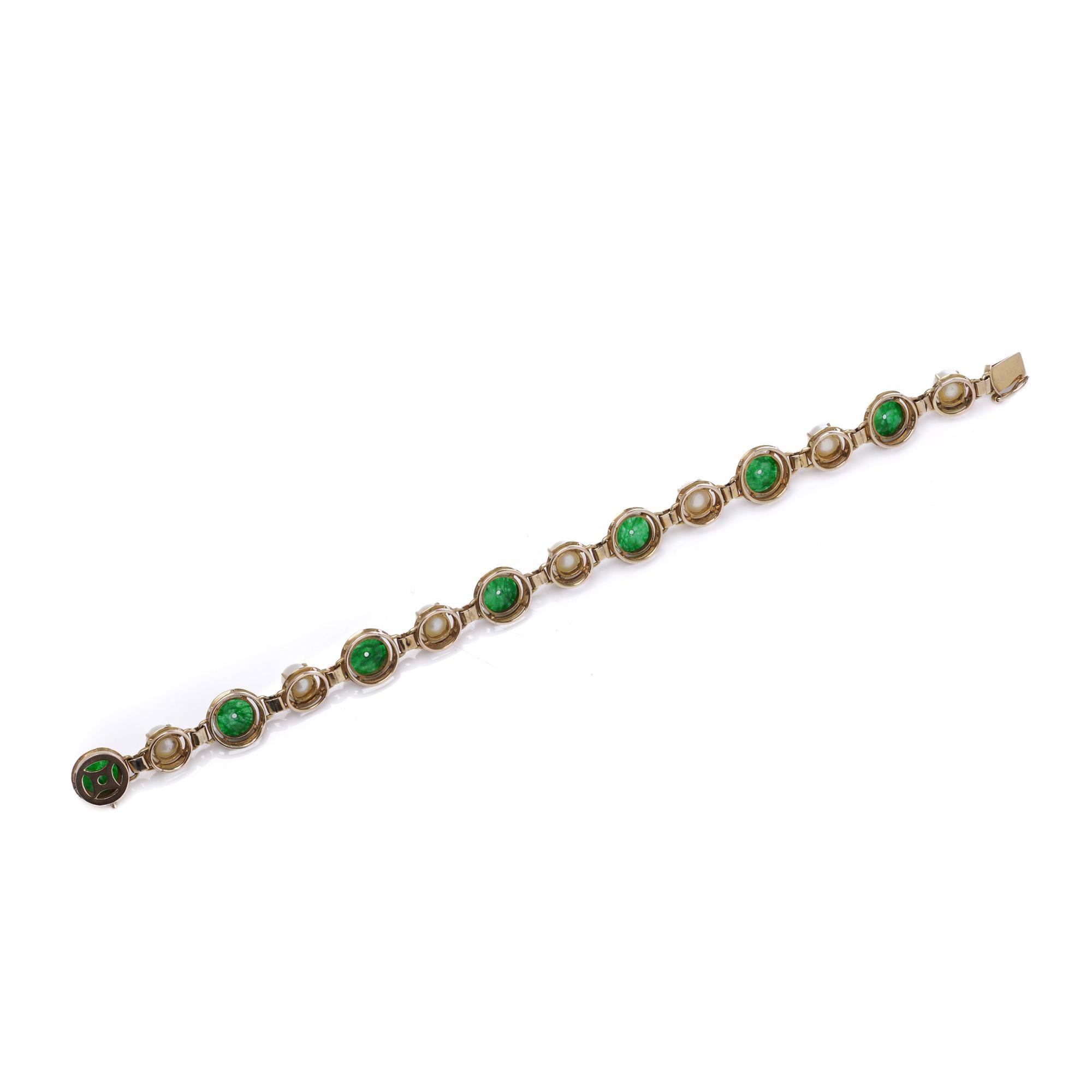 Ein charmantes Vintage-Armband aus 14-karätigem Gelbgold, das aus abwechselnd runden grünen Jadescheiben und leuchtenden weißen Zuchtperlen besteht. Jeder Edelstein ist einzeln in kreisförmige Glieder gefasst, die dem Schmuckstück Flexibilität und