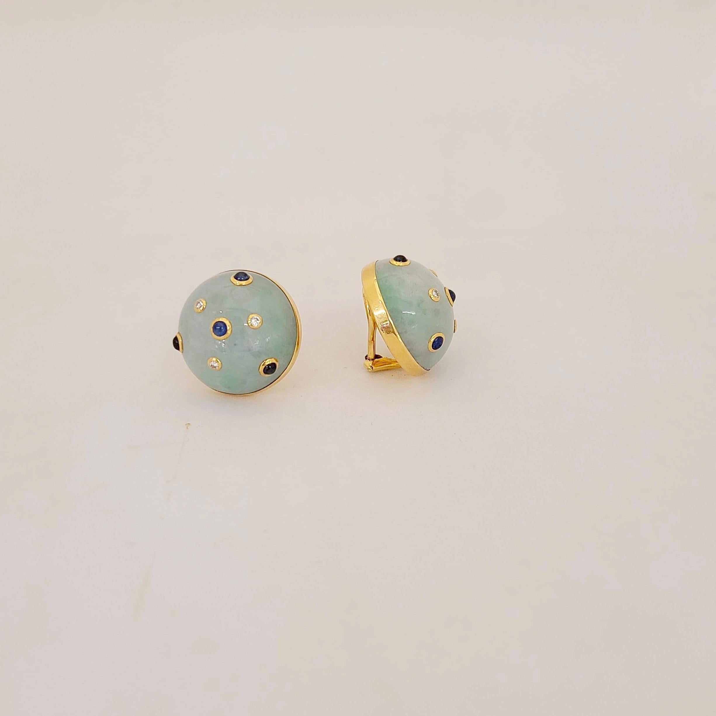 Lovely button earring designed with jadite which is a milky light greenish teal stone. Bezel set blue sapphire cabochons and diamonds have been sprinkled throughout. The earrings are clip on, but posts can be added. Diameter 3/4