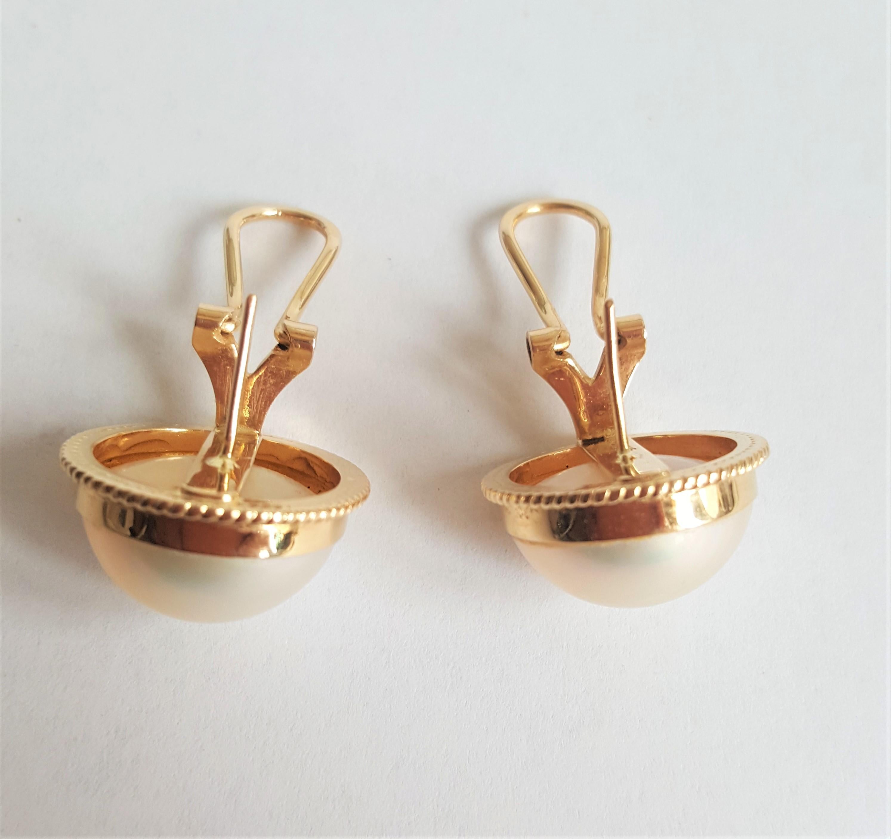 Beautiful 14kt yellow gold white mabe pearl earrings made by designer WAHING; they have friction post and are secured with omega backings. The pearls are in very nice condition and have a clean nacre. The earrings have a diameter of 18.5mm,  are