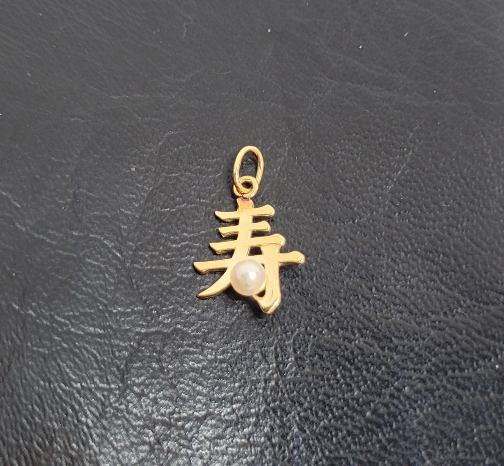 14kt yellow gold Mikimoto pearl charm pendant, measuring 12mm x 15mm. The Asian symbol on the pendant signifies 