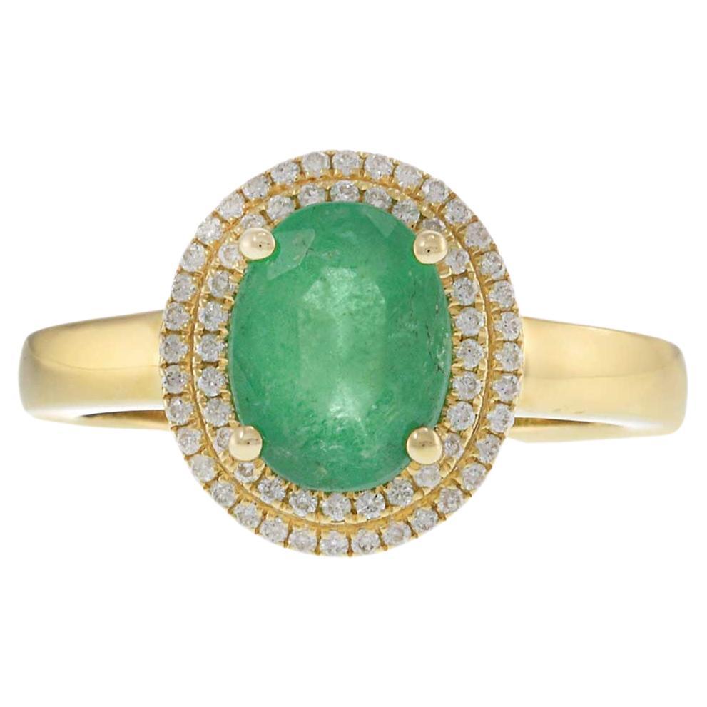 Anillo doble halo de oro amarillo de 14 quilates con esmeralda ovalada y diamante redondo