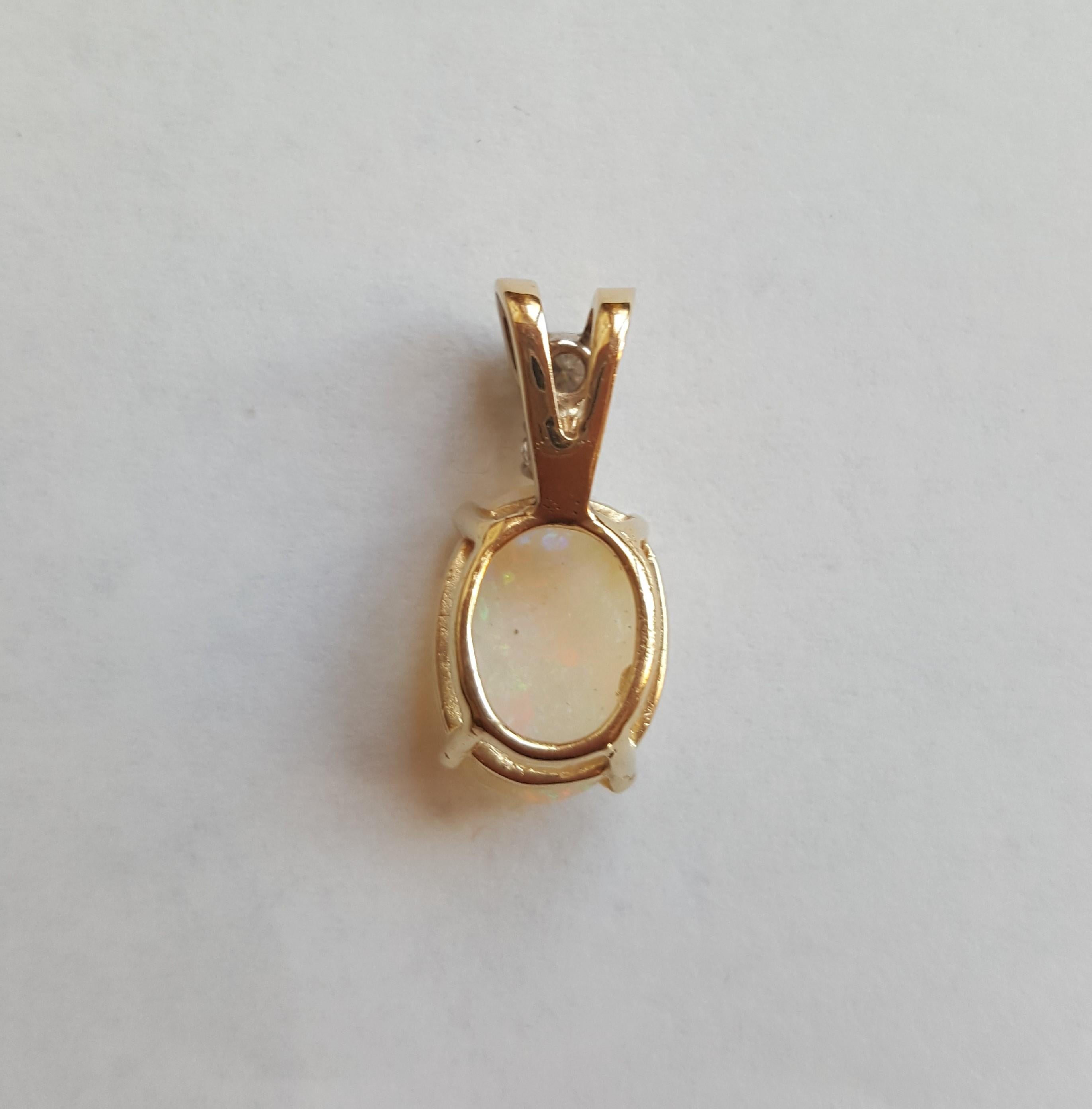 14kt Yellow Gold Oval Opal, Round Brilliant Diamonds Pendant, 12.6 mm X 8.9 X 3.3 mm Opal, 2 Diamonds Approx . 21cttw, 2 Grams Weight. The diamonds are 3.1mm  and 2.9 mm, H in Color and SI in Clarity.

With a reputation for timeless design, superior