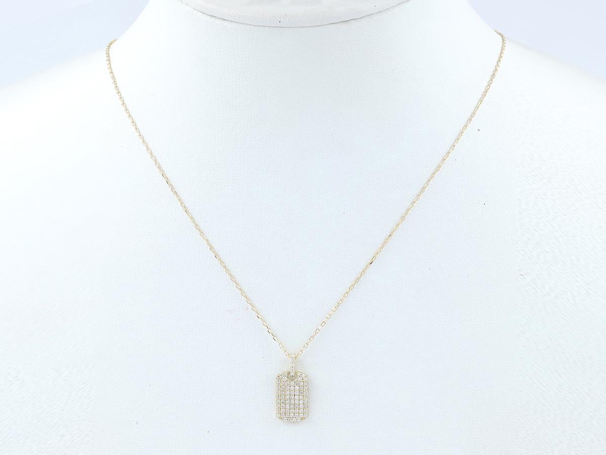 Der Anhänger hat die Form einer klassischen militärischen Erkennungsmarke, die jedoch mit einem luxuriösen Touch versehen ist. Die gesamte Vorderseite ist mit zahlreichen kleinen, runden Diamanten besetzt, die im Pavé-Stil dicht an dicht gefasst