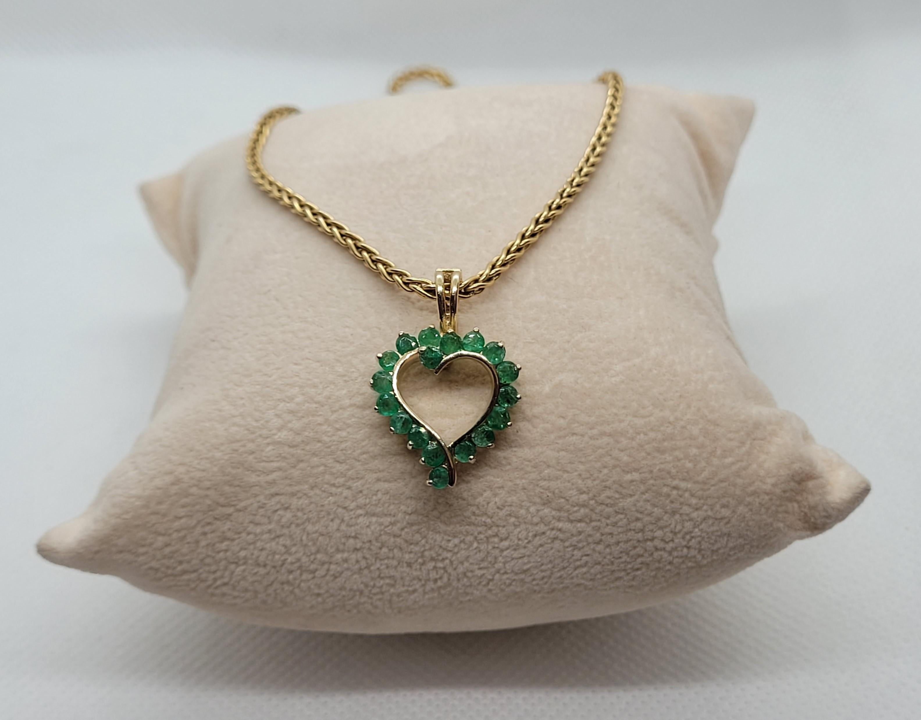 Lovely 14kt yellow gold heart pendant with 18 round emeralds of approximately 1.40cttw. The pendant is 23mm long by 17mm wide, stamped 585 14kt, with prong set emeralds that are 2.4mm in size, medium commercial grade quality, visible inclusions, and