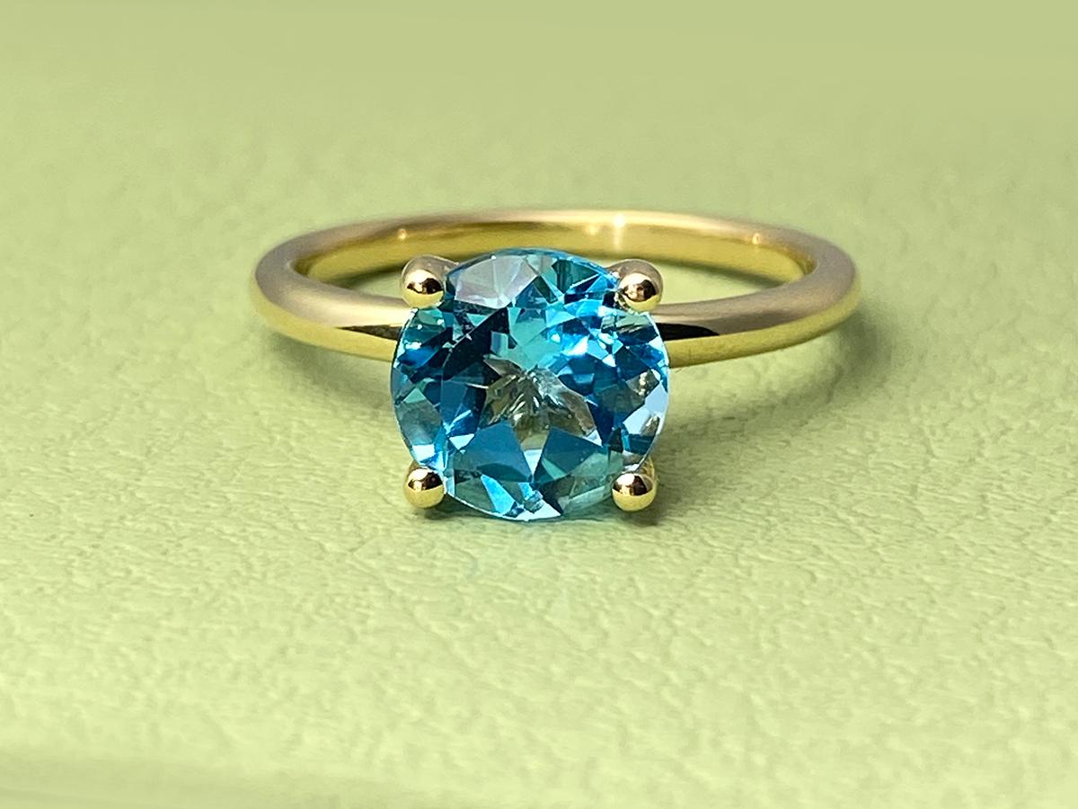 Il s'agit d'une bague de style solitaire, c'est-à-dire qu'elle met en valeur une seule pierre précieuse. La pierre est fixée par une monture classique à quatre griffes, qui maximise la quantité de lumière entrant dans la pierre pour en assurer la