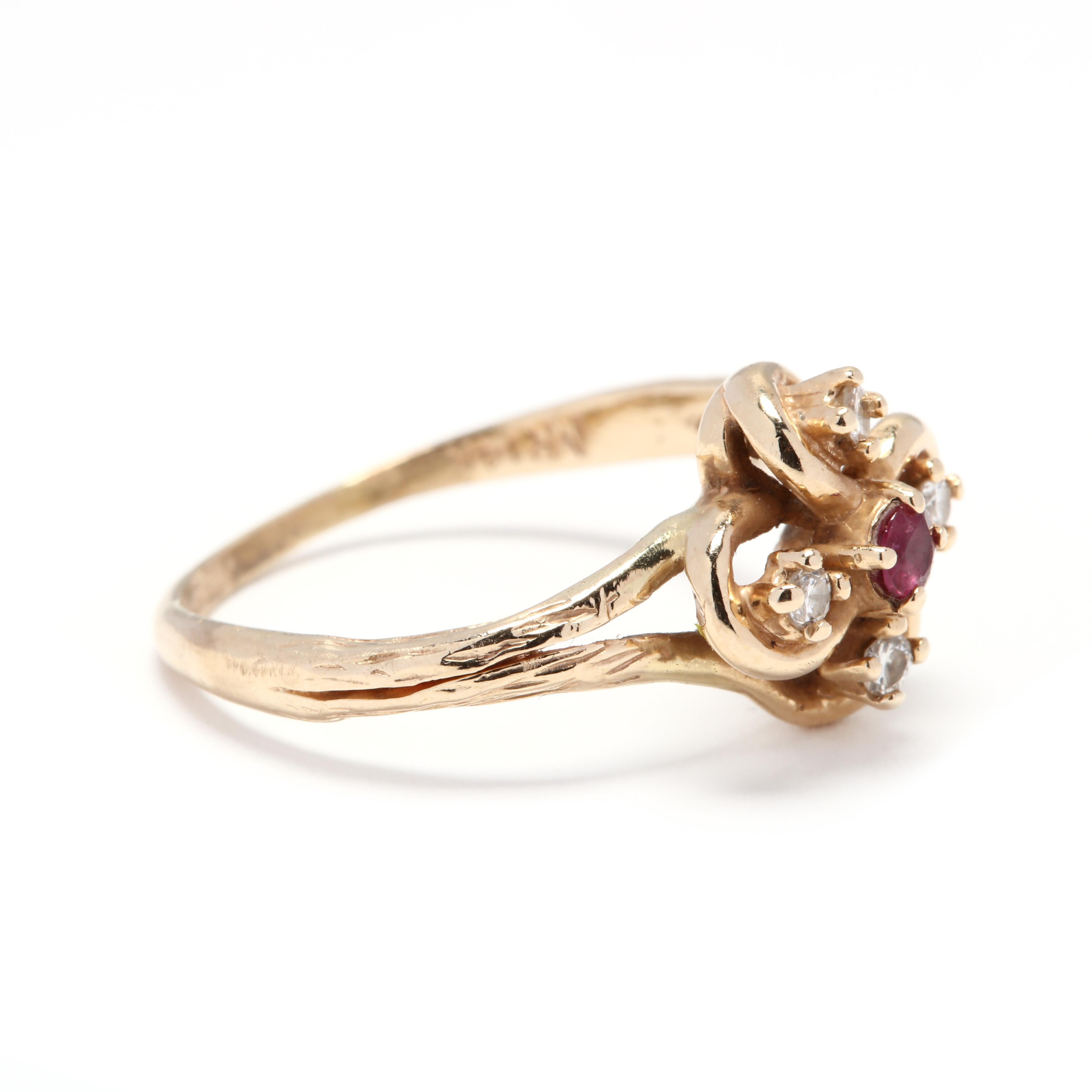A 14 karat yellow gold, ruby and diamond flower ring. In an open flower motif design set with a round cut ruby center stone surrounded by four round cut diamonds weighing approximately .08 total carats and a textured split shank.

Stones:
- ruby, 1