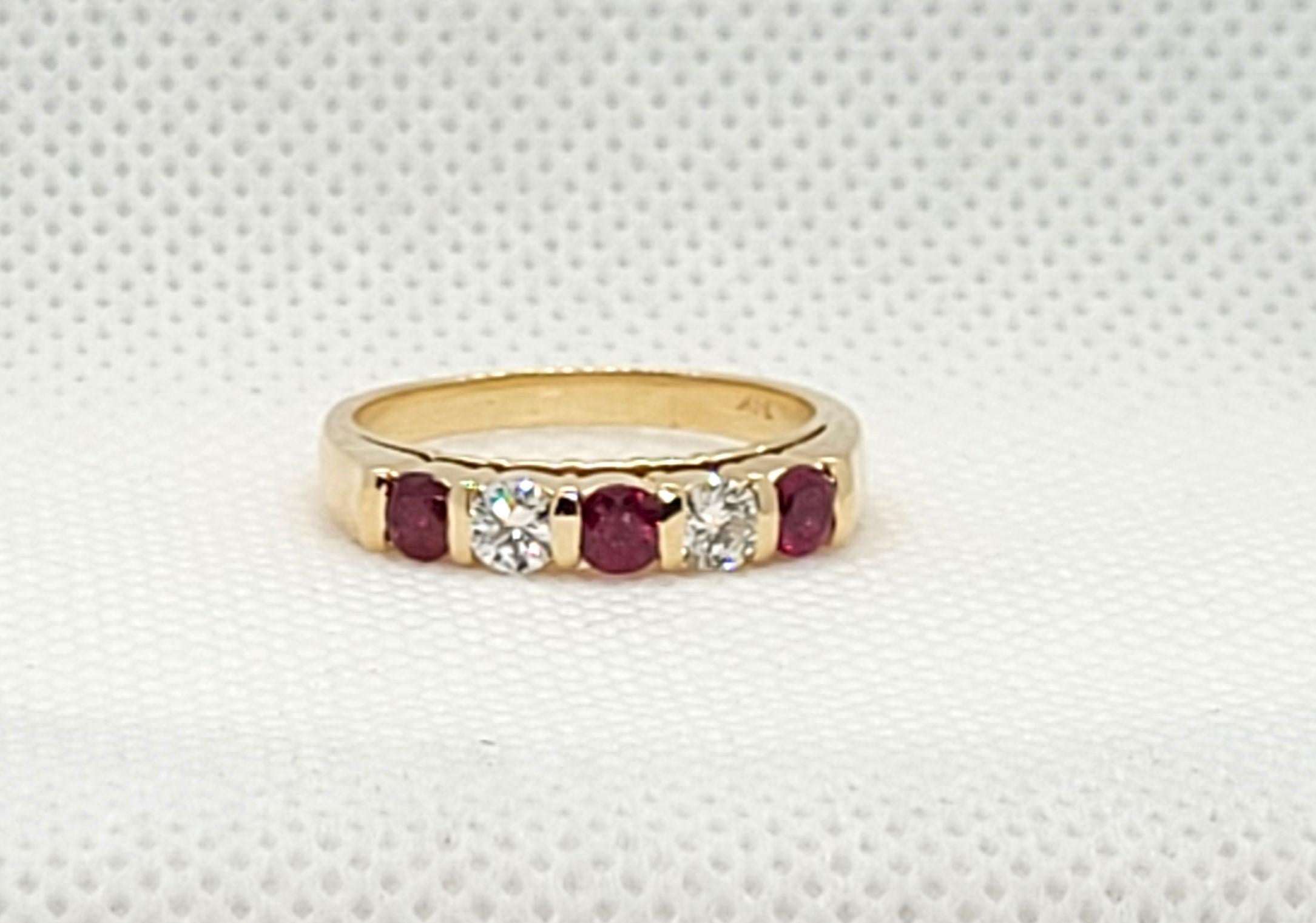 Bague pour femme en or jaune 14kt avec deux diamants ronds brillants en serti clos d'environ .30cttw et trois rubis ronds rouges/roses en serti clos d'environ .65cttw. Les deux diamants sont de couleur G/H et de pureté SI, avec une légère usure par