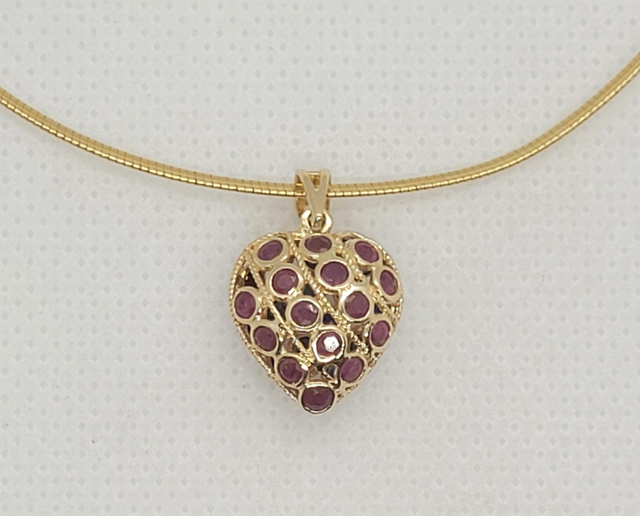 Unique 14kt yellow gold puff heart ruby sapphire pendant (reversible).  One side has bezel set round rubies and the other side has round navy blue sapphires. The pendant size is 15mm x 13mm x 8mm without the bail (bail 6mm x 3mm), weighing 1.9