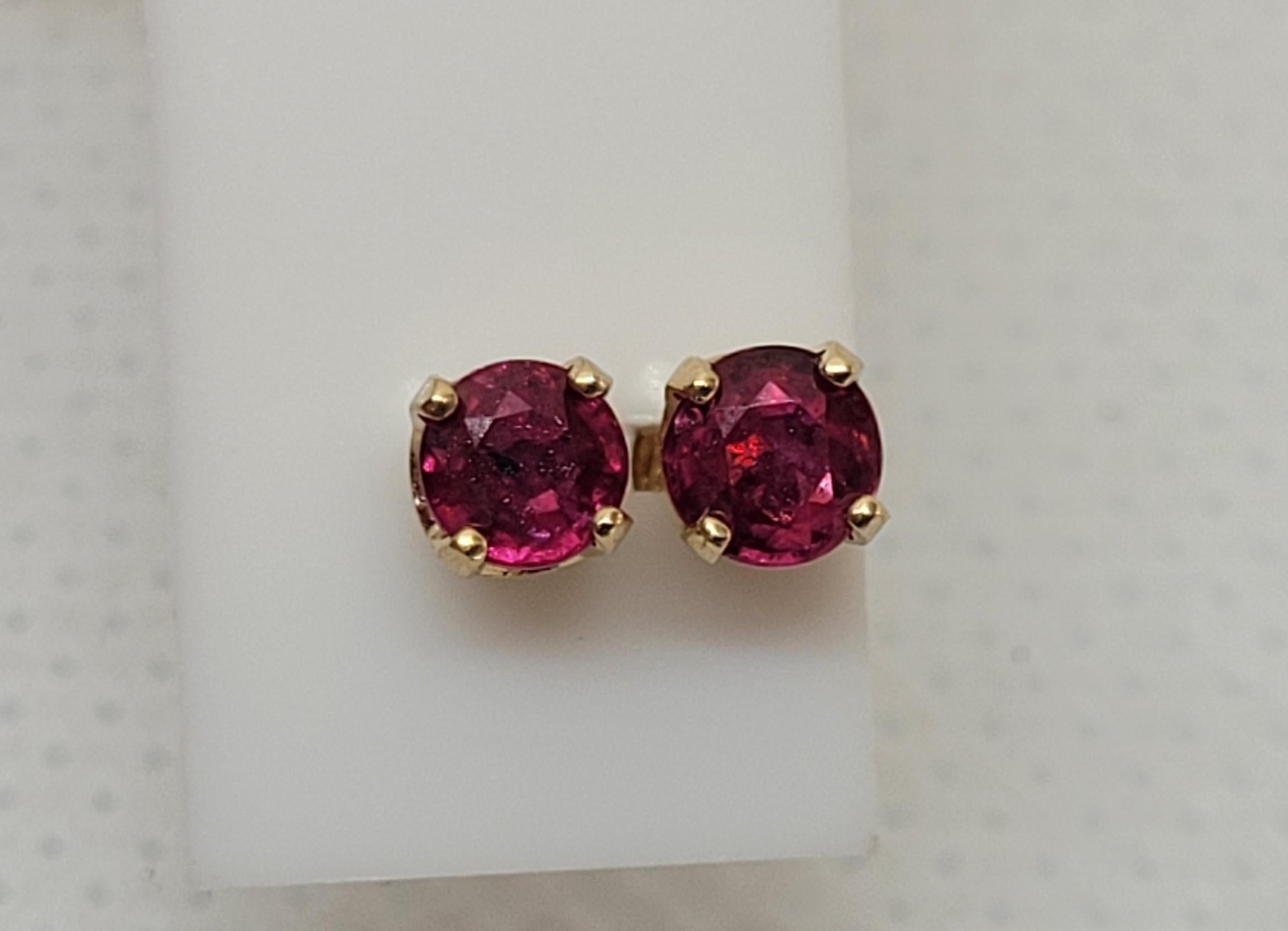 14kt yellow gold four prong stud friction post earrings with two round rubies of approximately .45cttw. The rubies have a red/pink color, have medium inclusions, are 3.7-3.8mm in diameter, and are in good condition. The studs are .75 grams total and