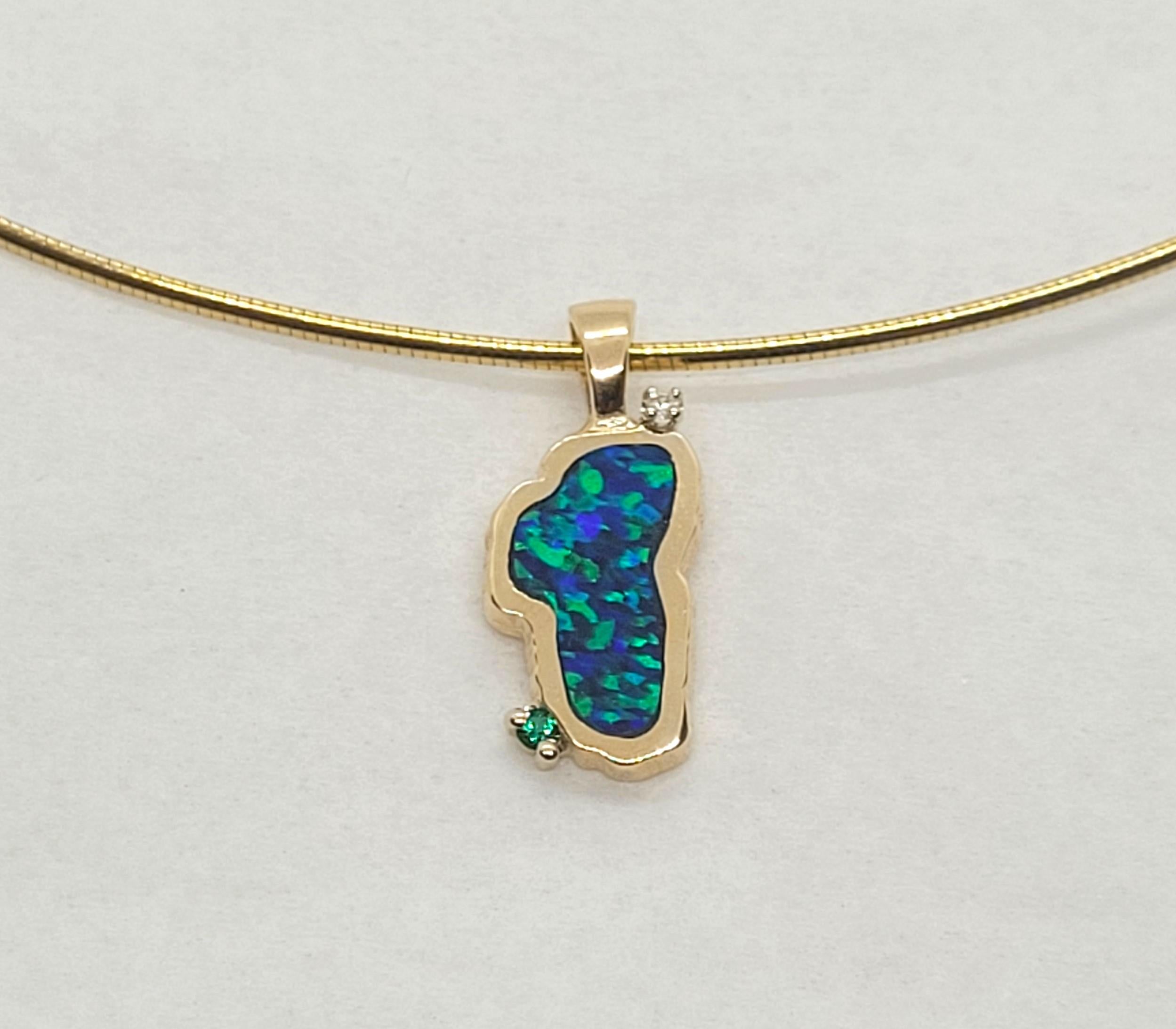 14kt yellow gold freeform pendant with a simulated opal, a round brilliant diamond, and round green stone. The pendant is 23 x 10mm in size (including the bail), 3.2 grams, stamped 14k, and overall in very good condition (chain is sold separately).