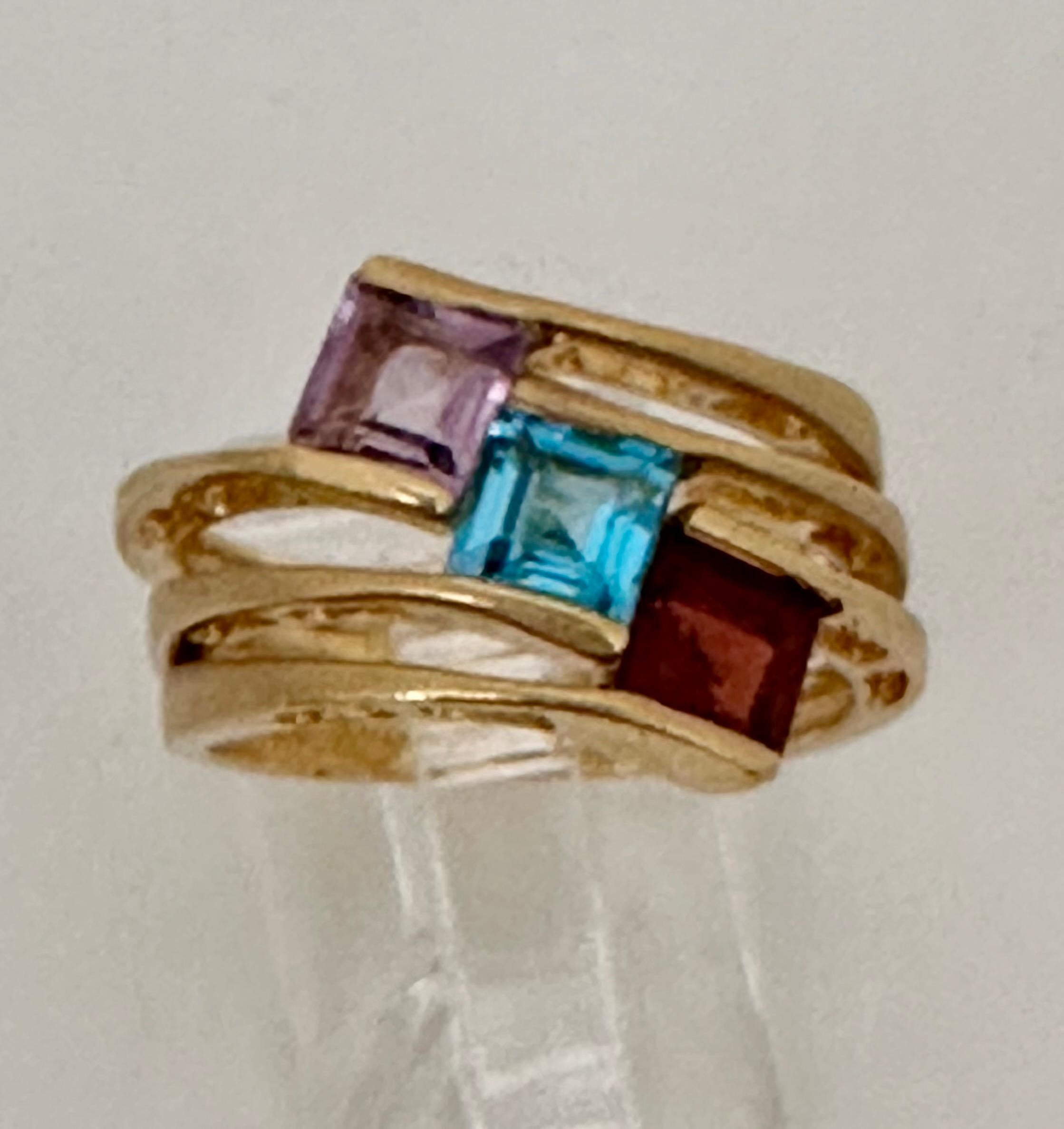 14kt Yellow Gold 5mm Square Cut Garnet Amethyst and Blue Topaz 14mm Wide Band Ring Sz 7

Garnet:
The name garnet derives from the Latin word for grain due to the similarity between their rounded crystals and a pomegranate's seeds. Garnet is the