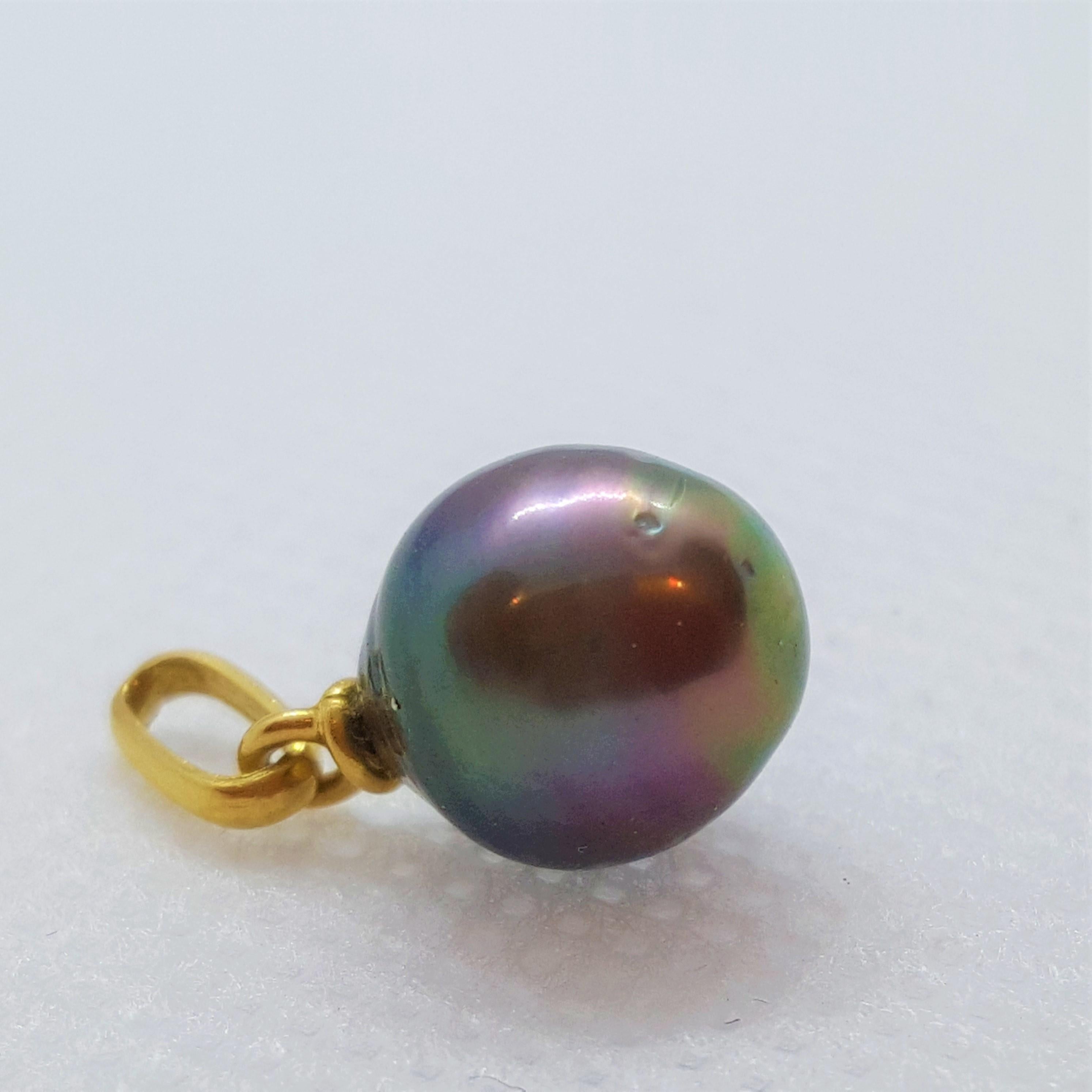 A beautiful 8.8mm Tahitian pearl with colors of peacock, eggplant, and gray set in a 14kt yellow gold pendant with bail. The pearl has a nice luster and clean nacre. The chain is sold separately.  We can assist in ordering you a chain in your length