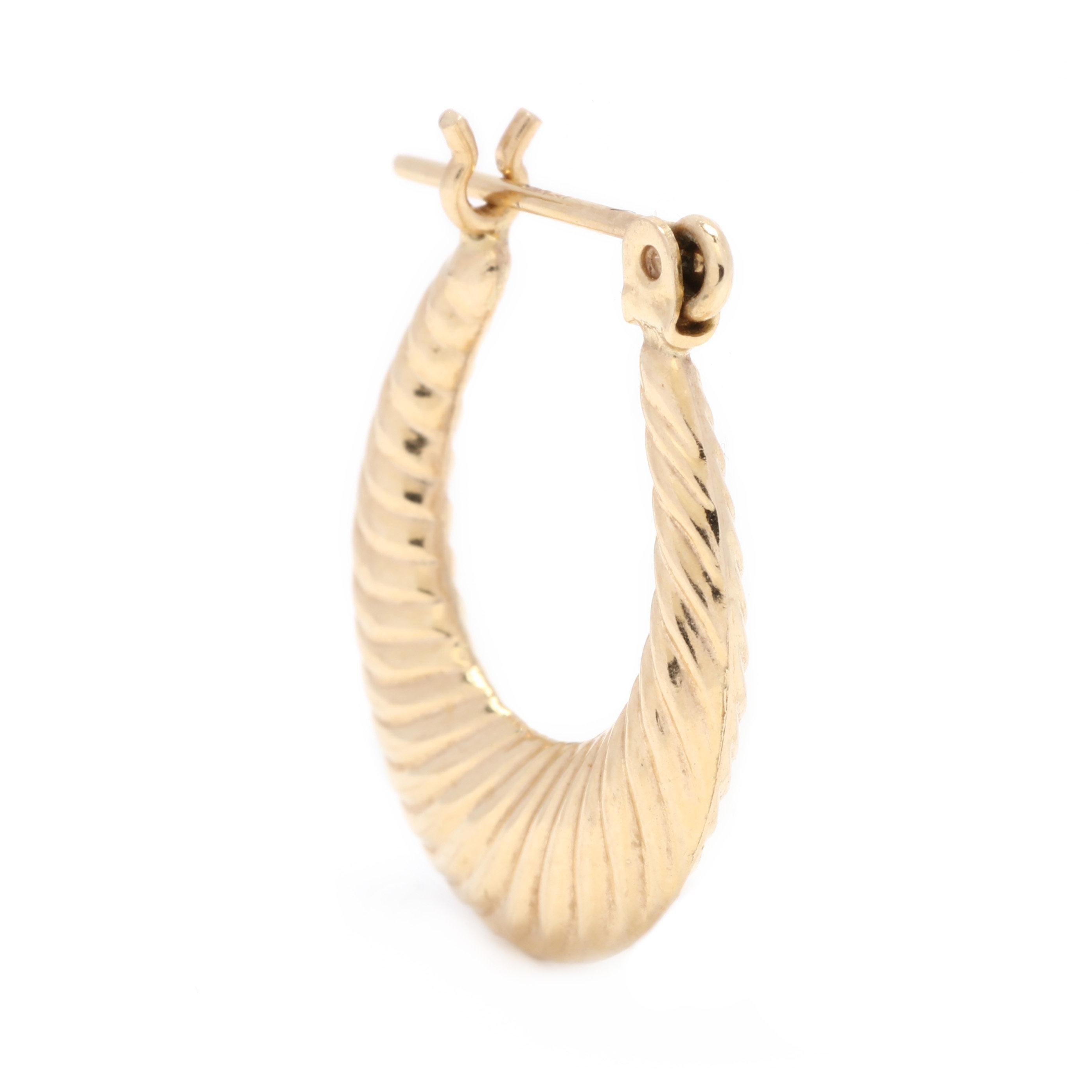 A pair of 14 karat yellow gold tapered ribbed hoop earrings. These earrings feature a tapered oval design with ribbed detailing and a snap closure.

Length: 3/4 in.

Width: 9/16 in.

Tube Width: 3 mm.

.9 dwts.