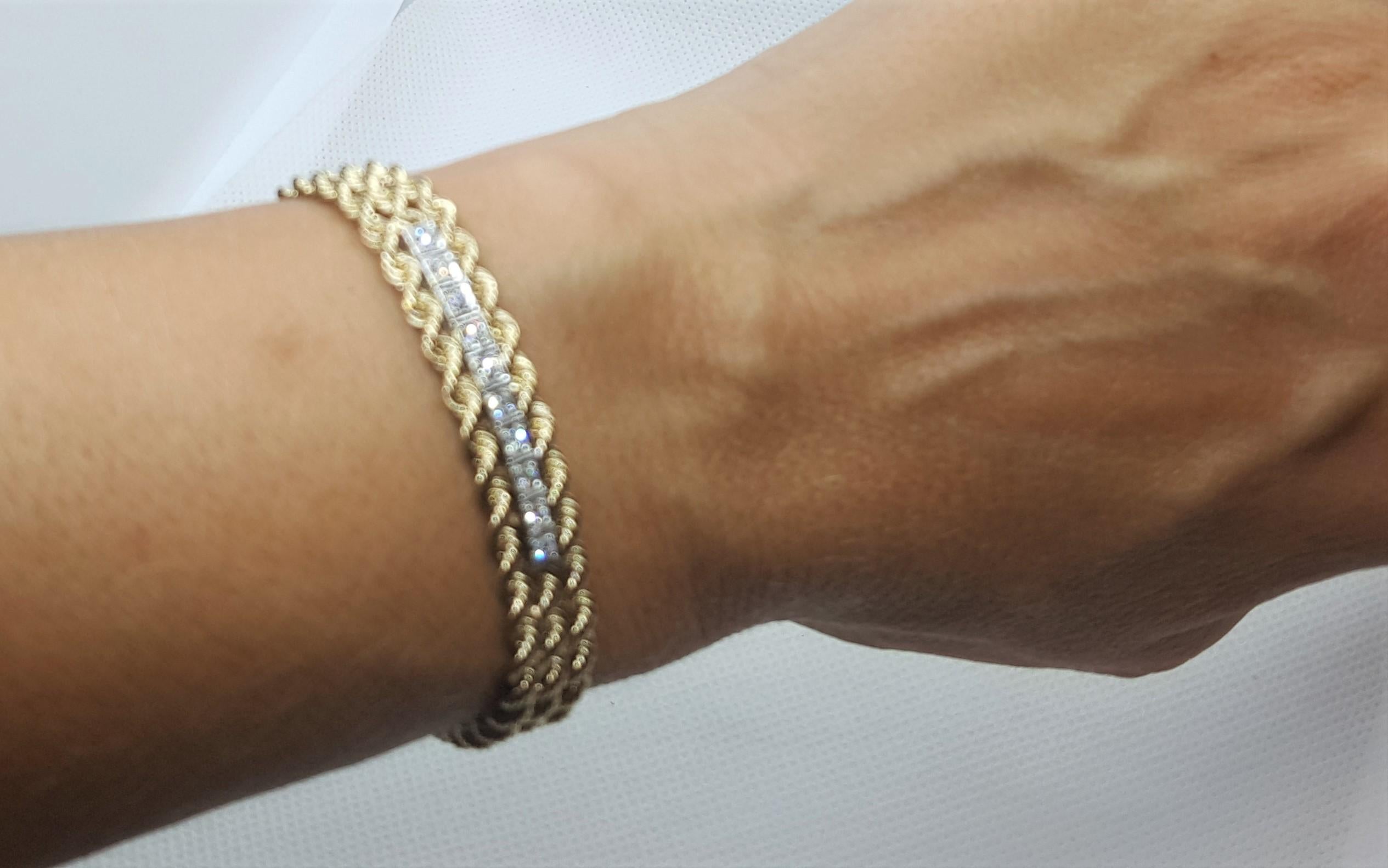 14kt yellow gold triple rope bracelet with 14kt white gold settings with 10 round brilliant diamonds of approximately .20cttw. The diamonds are g color, SI clarity, and proportioned well. The bracelet is a total of 7.25 inches, 9.6mm wide, and is