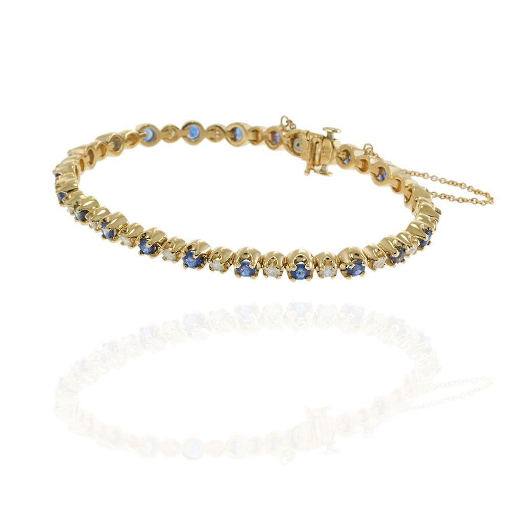 Ce bracelet de tennis vintage en or jaune 14KT présente un motif alterné de saphirs bleus de taille ronde et de diamants de qualité G-VS1. Les 2,50 carats de saphirs et les 1,84 carats de diamants sont sertis dans un design classique qui rayonne de